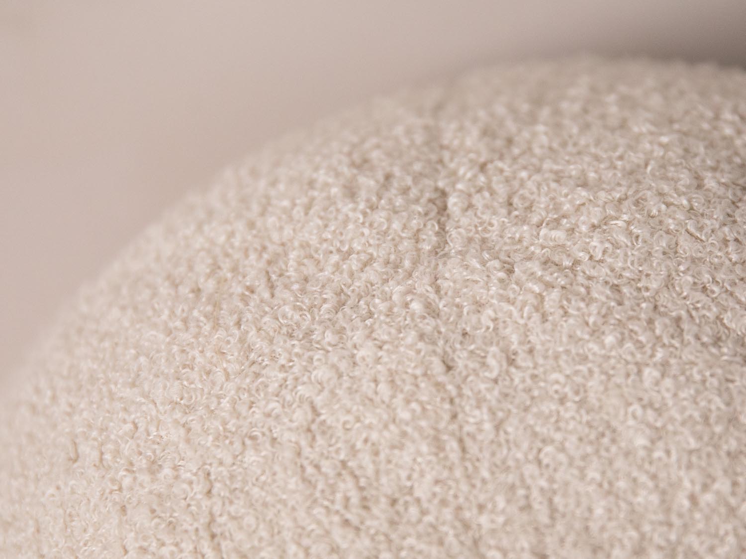 Rundes Ball Kissen in sanftem Beige von Micadoni, perfektes Accessoire für eine einladende Wohnatmosphäre, vielseitig einsetzbar auf Sofa oder Bett.