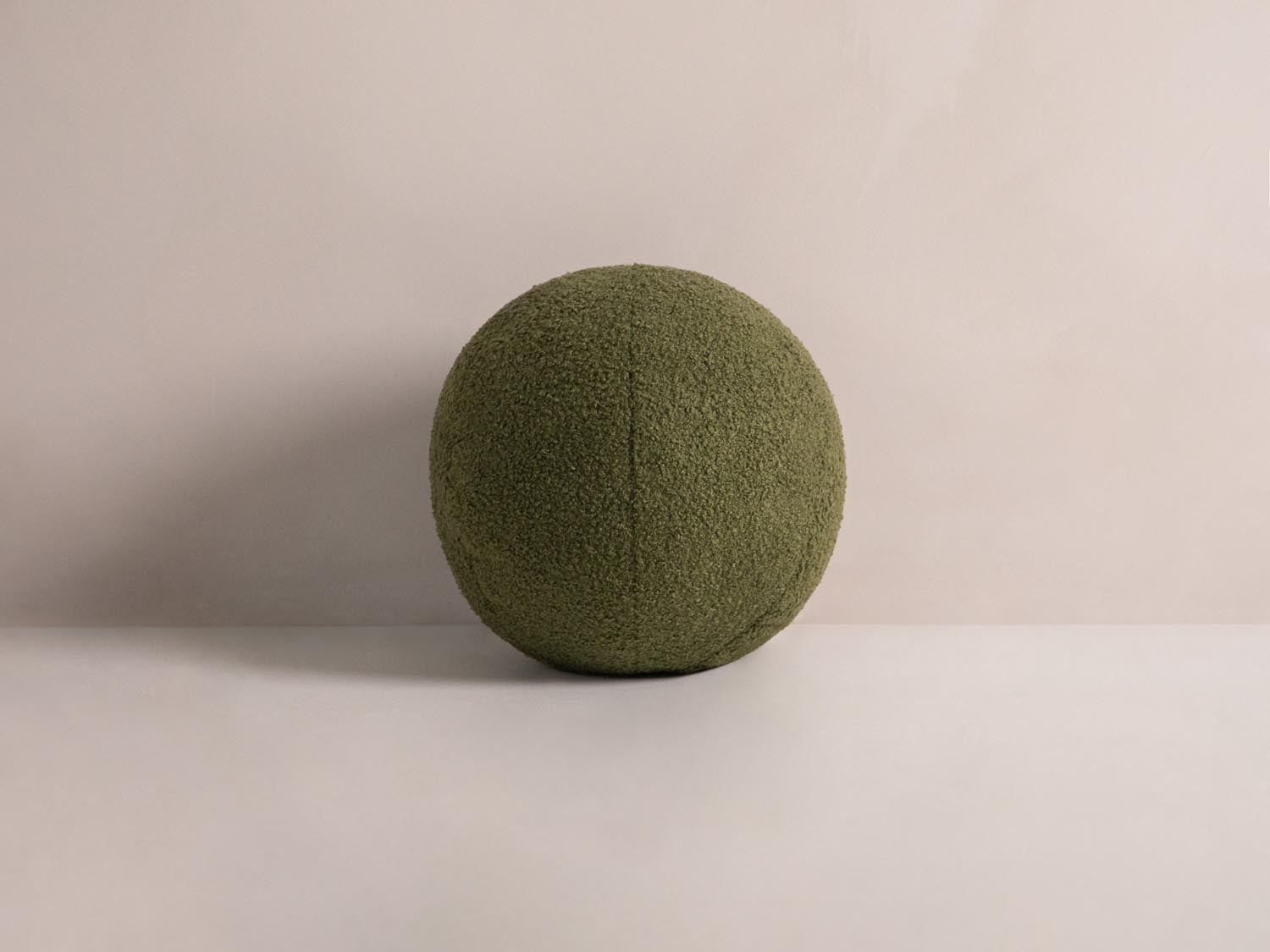 Rundes, grünes Ball Pillow von Micadoni, ideal als dekoratives Kissen für stilvolle Wohnräume. Weich und einladend, perfekt für jedes Sofa.