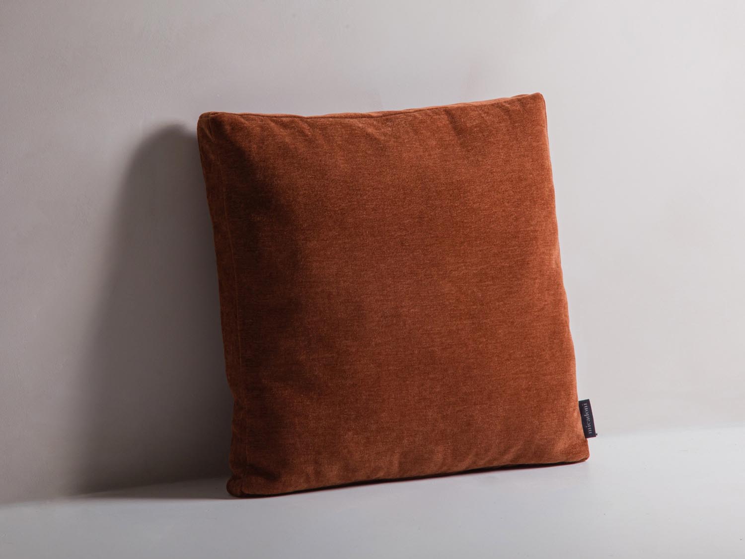 Stylisches Mono Pillow in warmem Ziegelrot von Micadoni, ideal für eine moderne Wohnraumgestaltung. Perfekt als Deko-Element für jedes Sofa.