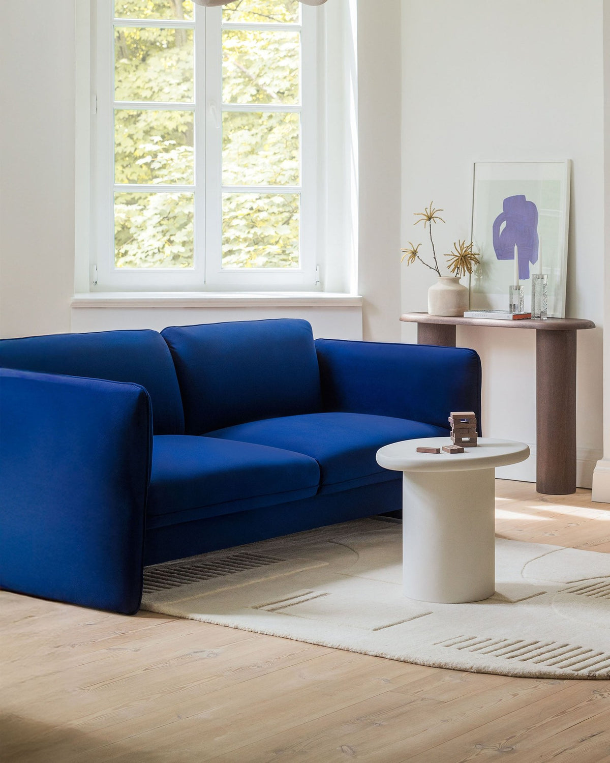 Kobaltblauer Pouf Georgia von Micadoni mit samtigem Stoffbezug, rechteckiger Form und niedrigen Kunststoffbeinen, freigestellt fotografiert.