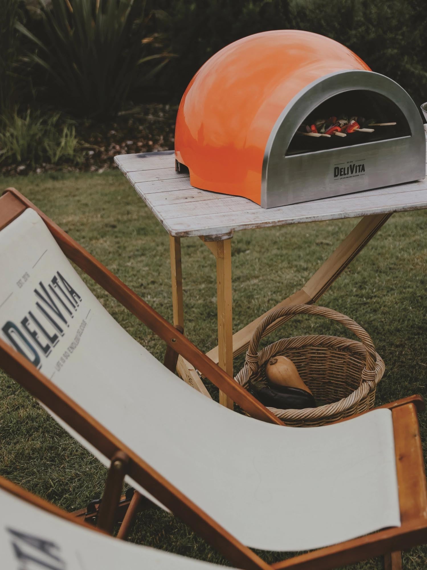 Der tragbare Delivita Holzofen in Orange bietet stilvolles Outdoor-Kochen und backt köstliche Pizzen und andere Gerichte.