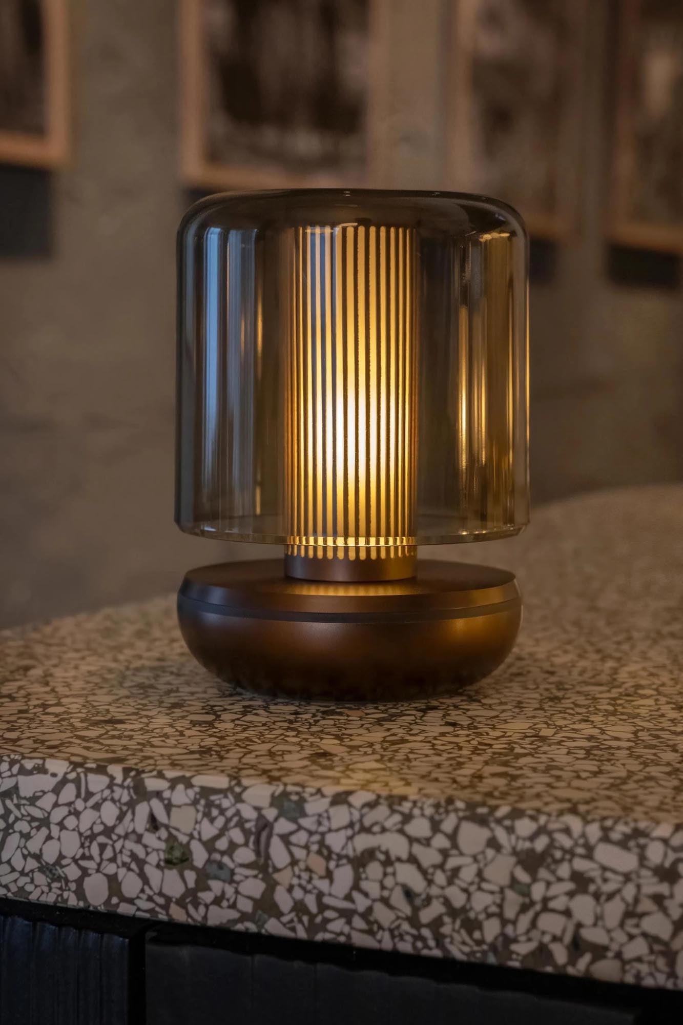 Die Firefly Tischlampe von Humble Light in Bronze mit smoked Glas (11.8x8.6cm) bietet stilvolle und warme Beleuchtung.