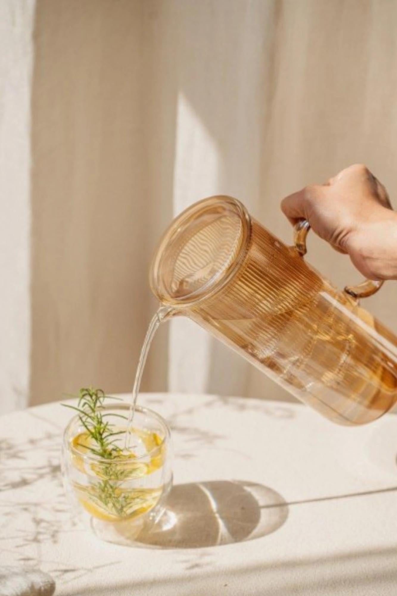 Elegante 1.2l Karaffe aus hochwertigem Borosilikatglas mit goldfarbenem Akzent, ideal für stilvolles Servieren von Getränken.