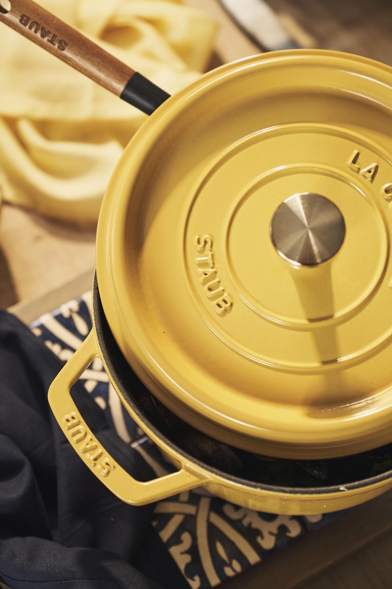 Runde Gusseisen-Cocotte von Staub, 26 cm, 5.25 l, in leuchtendem Citron-Gelb. Ideal für Schmorgerichte und elegantes Servieren.