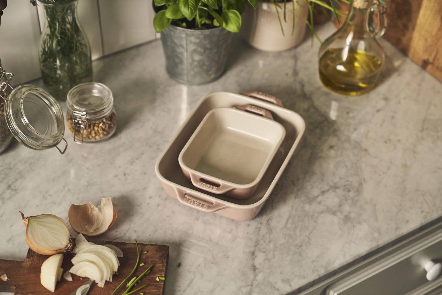 Zweiteiliges Keramik-Ofenformset in zartem Rosa von Staub, perfekt für Backen und Servieren, Grössen: 20x16 cm und 27x20 cm.