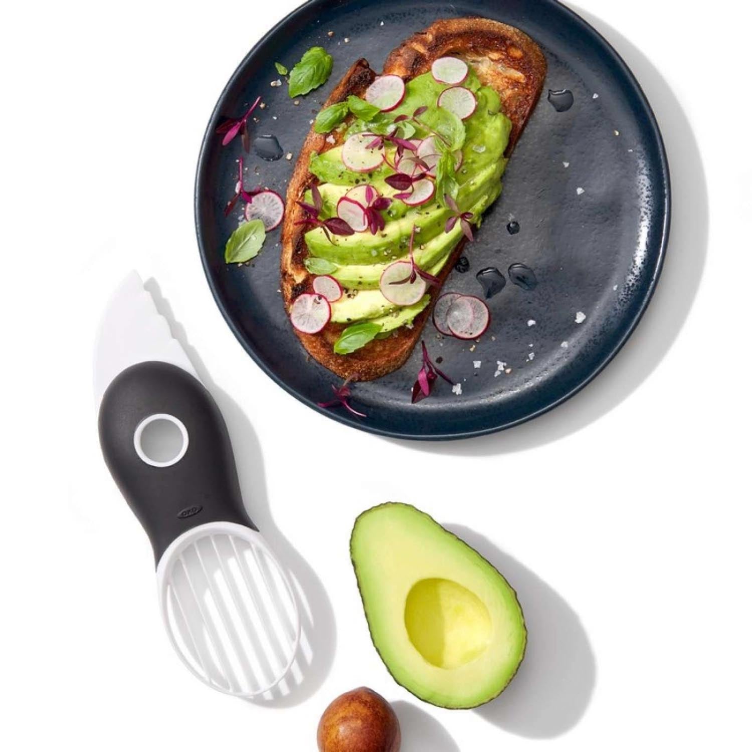 Der weisse OXO 3-in-1 Avocadoschneider: Praktisches Küchenwerkzeug zum Schneiden, Entkernen und Portionieren von Avocados.
