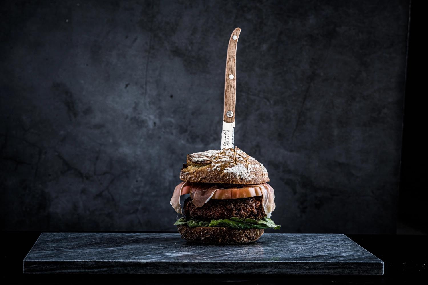 Hochwertiges Laguiole Steakmesser mit robustem Eichenholzgriff und scharfer gezackter Klinge, perfekt für Fleischliebhaber.