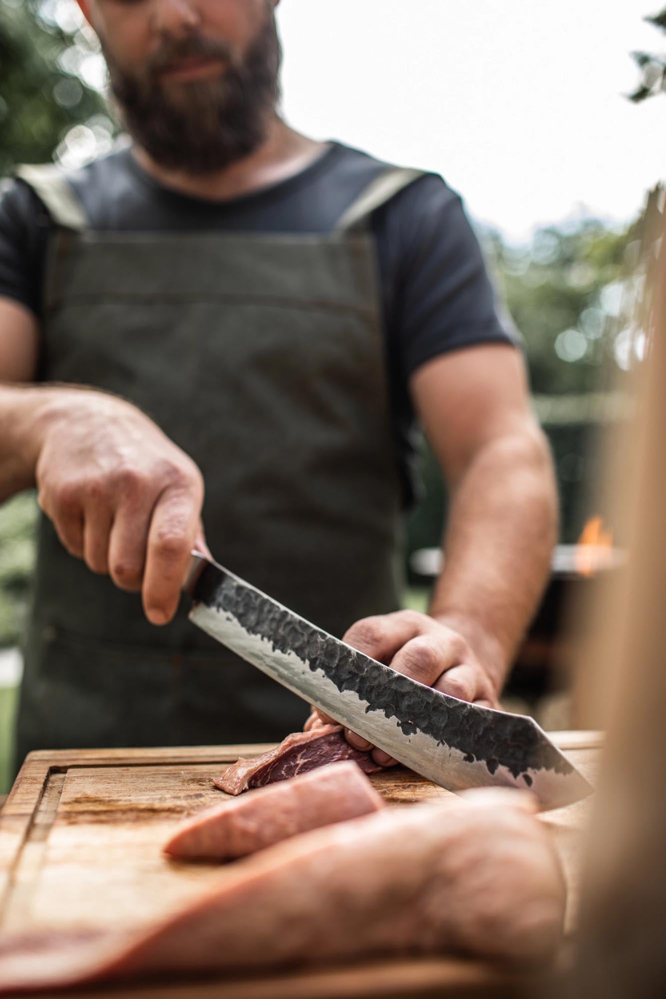 Das 25cm Forged Olive Metzgermesser kombiniert eine scharfe Klinge mit einem stilvollen Griff aus Olivenholz.