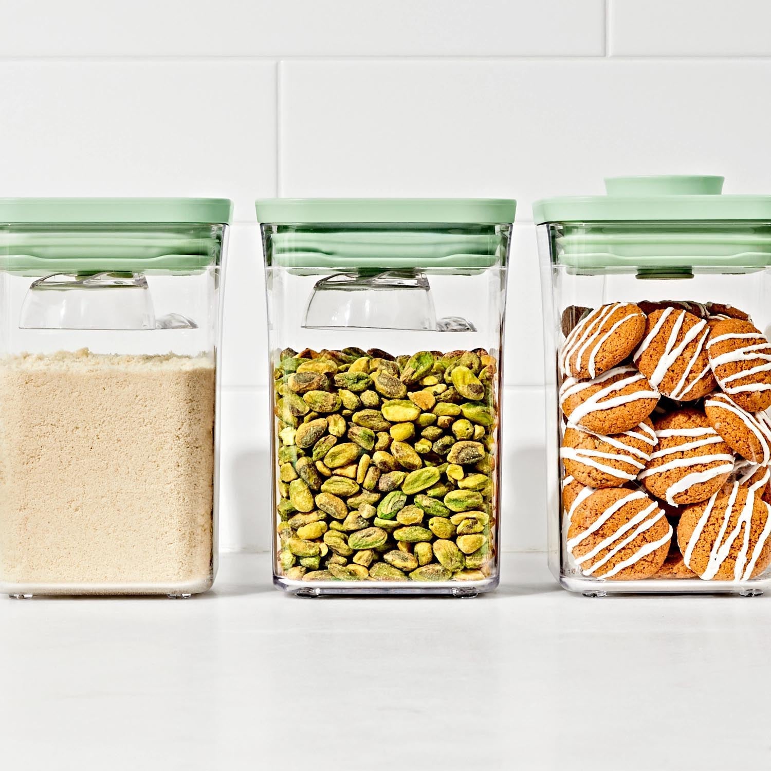 Set aus 3 OXO Good Grips Pop Behältern mit grünem 30ml Löffel, ideal für präzise Dosierung und frische Aufbewahrung von Lebensmitteln.