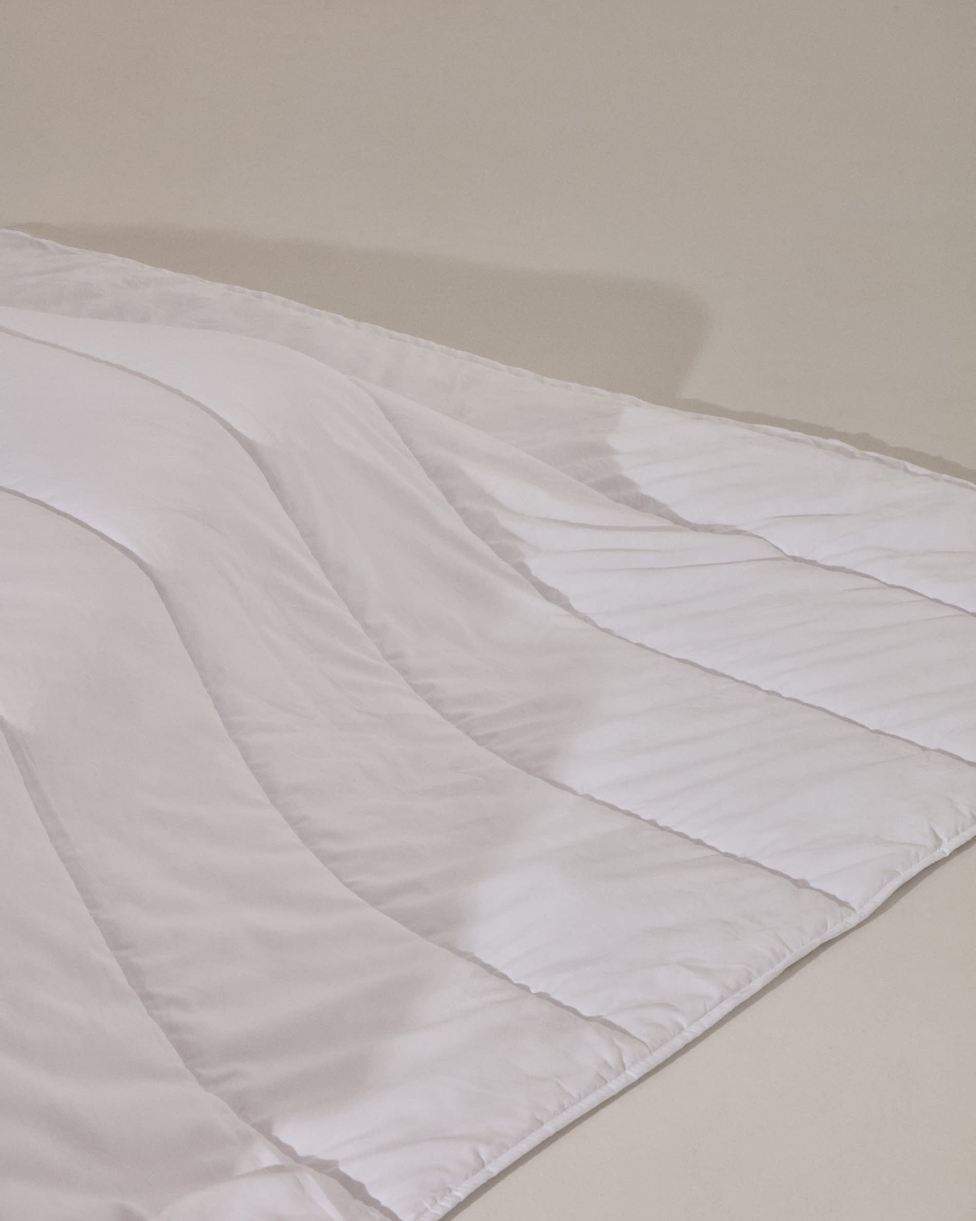 Luxuriöse Steppdecke Atra mit 70% Daunen und 30% Federn, ideal für 150/160 cm Betten, hergestellt in Spanien von Kave Home.