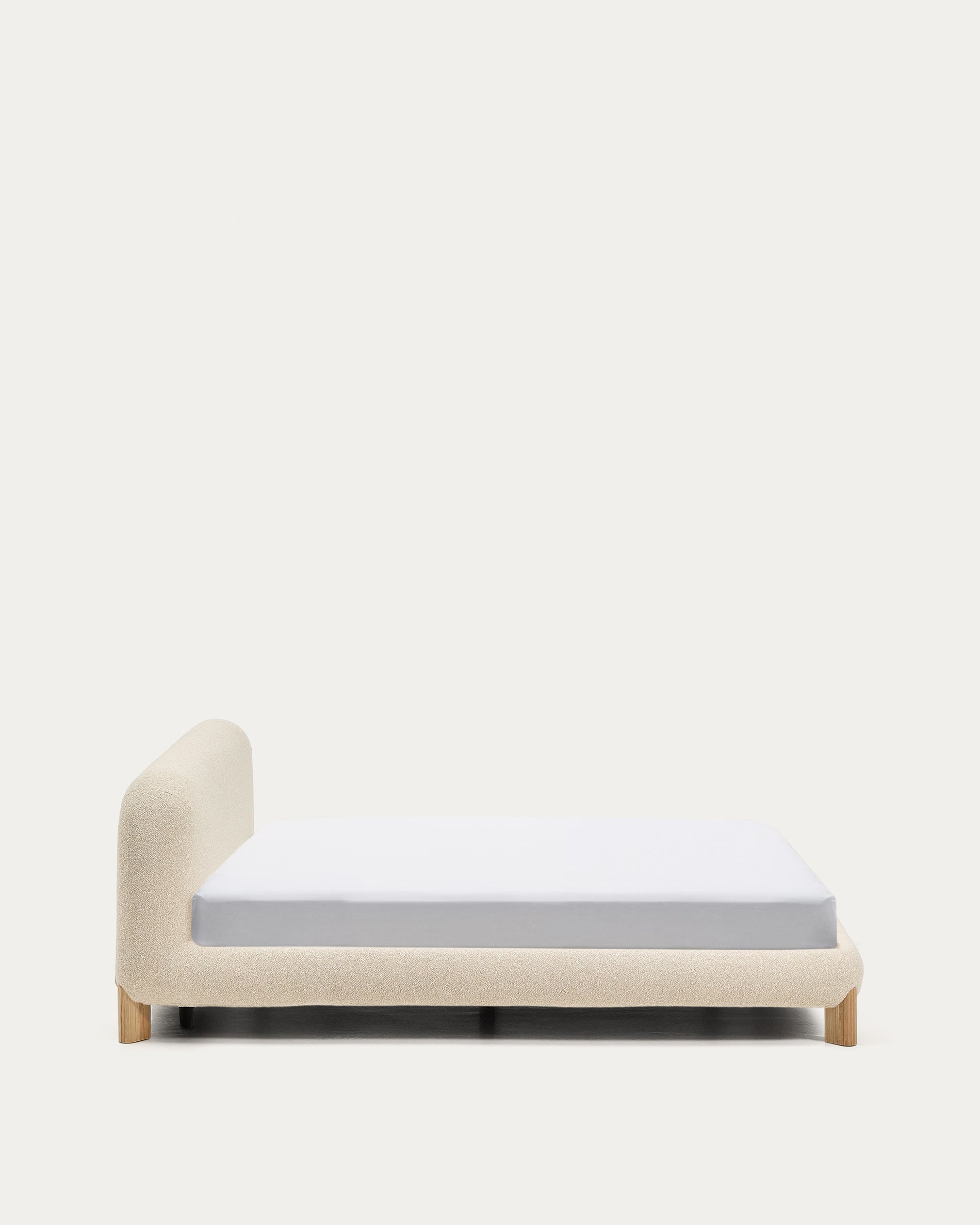 Entdecken Sie das Bett Odina von Kave Home: Stilvolles Design mit ecrufarbenem Boucléstoff, abnehmbarer Bezug für einfache Reinigung und stabile Eschenbeine.