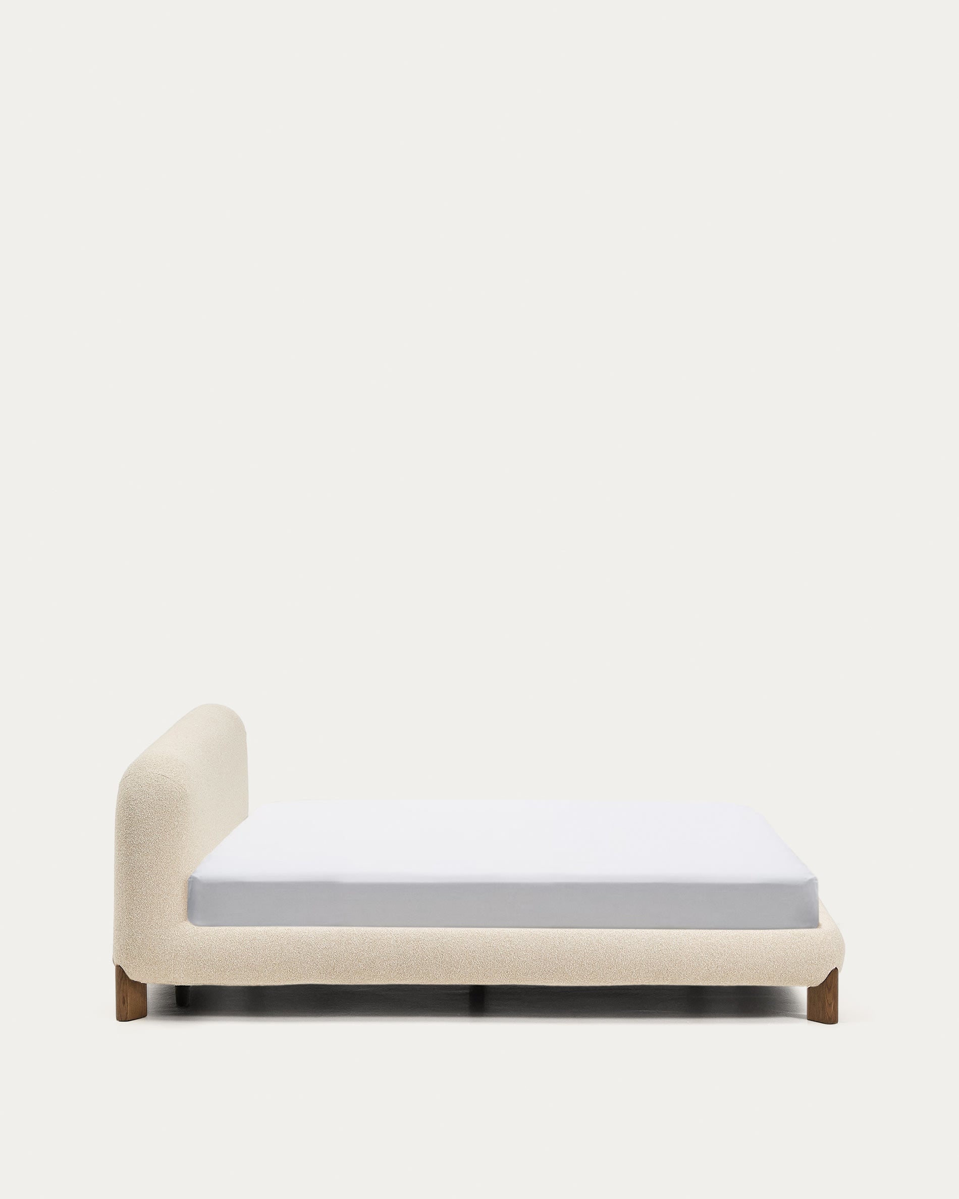 Entdecken Sie das Bett Odina von Kave Home: Stilvolles Design mit ecrufarbenem Boucléstoff, abnehmbarer Bezug für einfache Reinigung und stabile Eschenbeine.