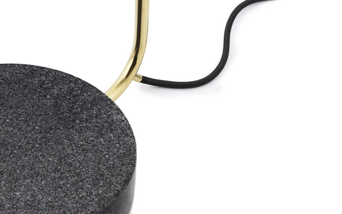 Grant Floor Lamp von Normann Copenhagen: schwarze Stehleuchte mit schlankem Stab, neigbarem Leuchtenkopf und textilummanteltem Kabel.