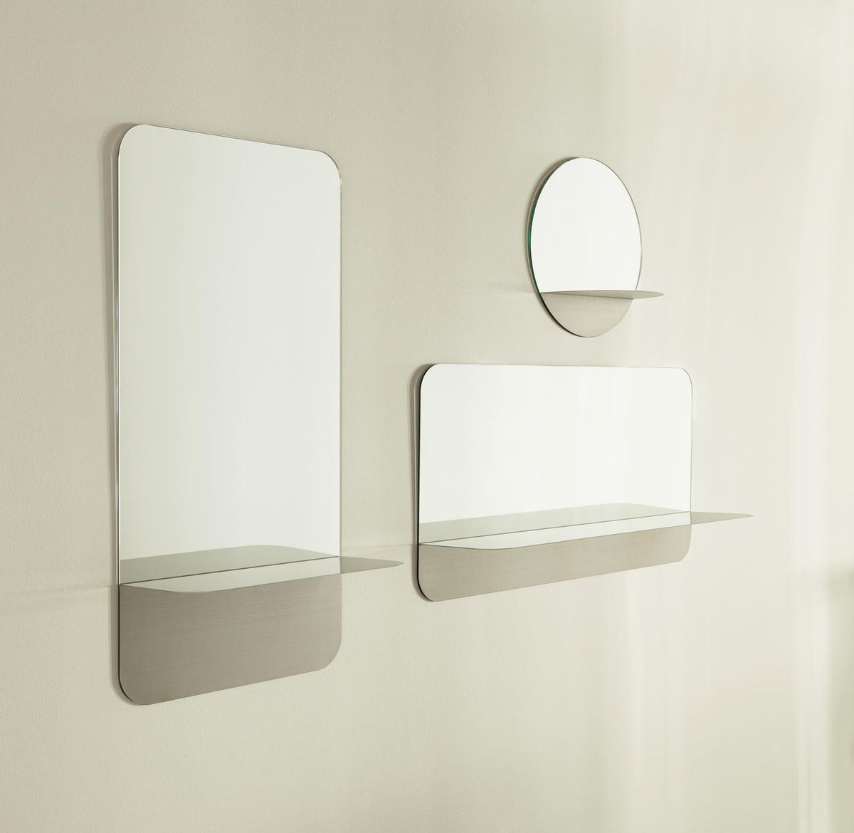 Runder Wandspiegel aus Spiegelglas mit grauem Stahlrahmen und integriertem Ablageboden, minimalistisches geometrisches Design von Normann Copenhagen.