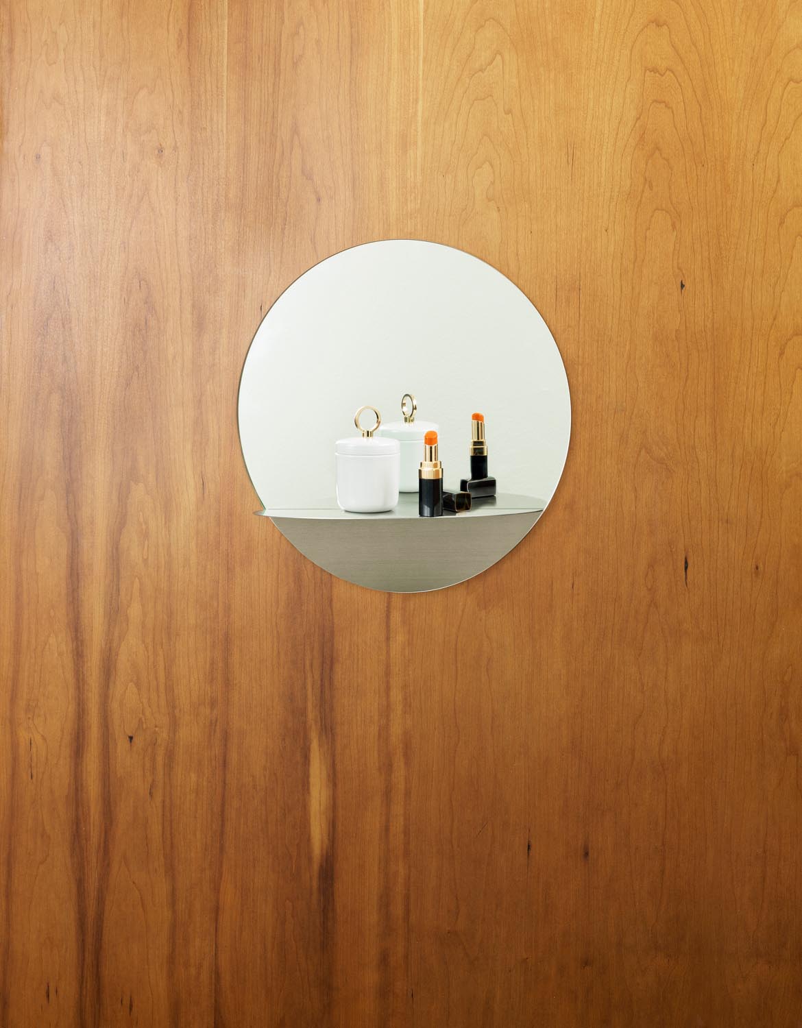 Runder Wandspiegel aus Spiegelglas mit grauem Stahlrahmen und integriertem Ablageboden, minimalistisches geometrisches Design von Normann Copenhagen.