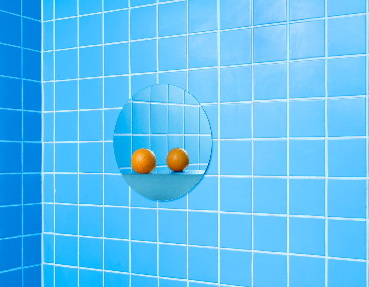 Runder Wandspiegel aus Spiegelglas mit grauem Stahlrahmen und integriertem Ablageboden, minimalistisches geometrisches Design von Normann Copenhagen.