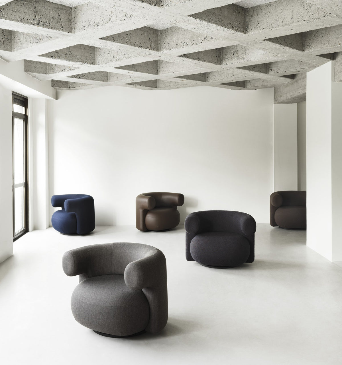 Grauer Burra Lounge-Sessel von Normann Copenhagen mit rundem, gepolstertem Sitz, geschwungener Rückenlehne und Drehfuss aus Holz.