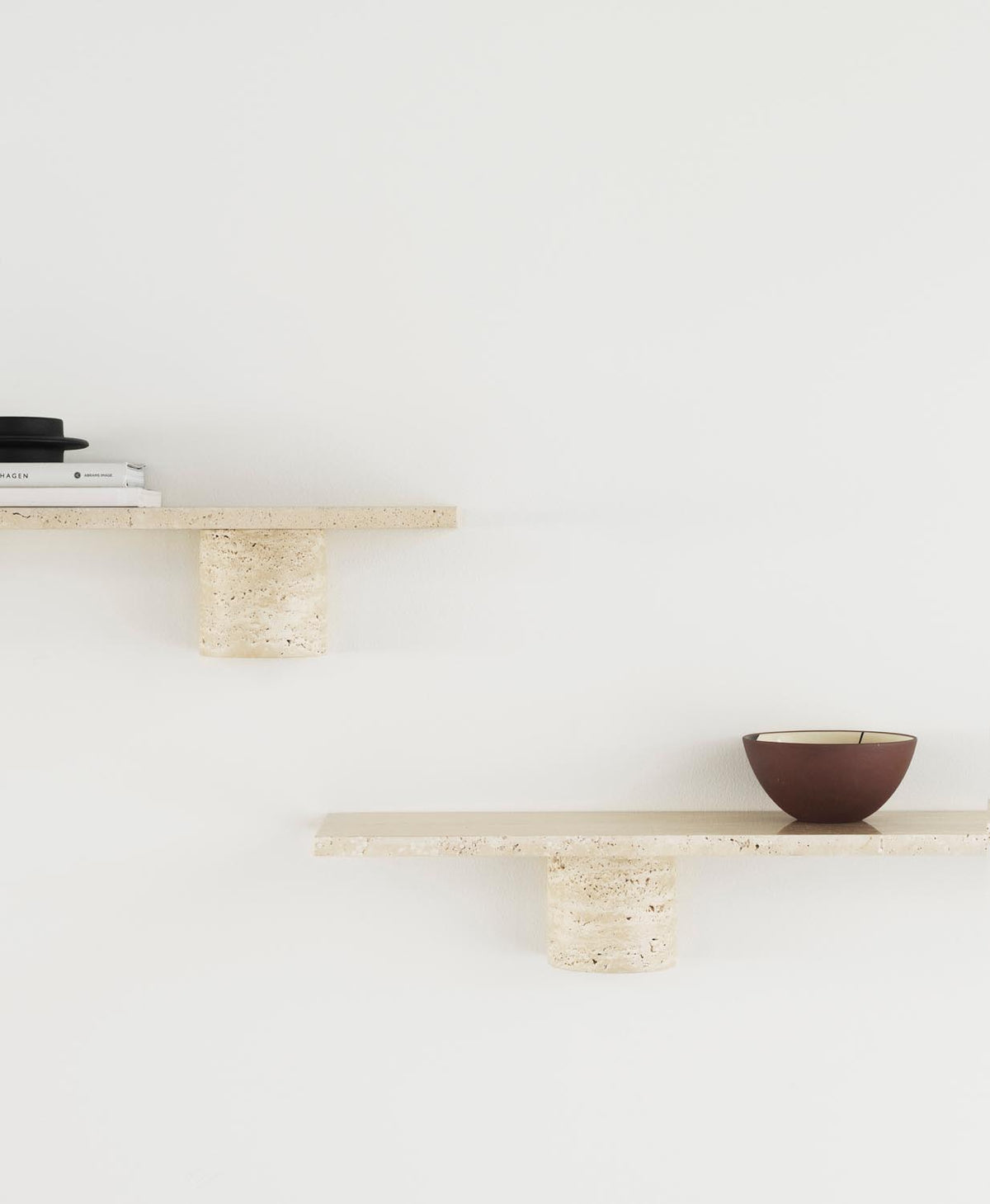 Wandregal Sten 80 cm in Travertin von Normann Copenhagen: schlichte Steinplatte auf zwei abgerundeten Regalträgern aus Naturstein.