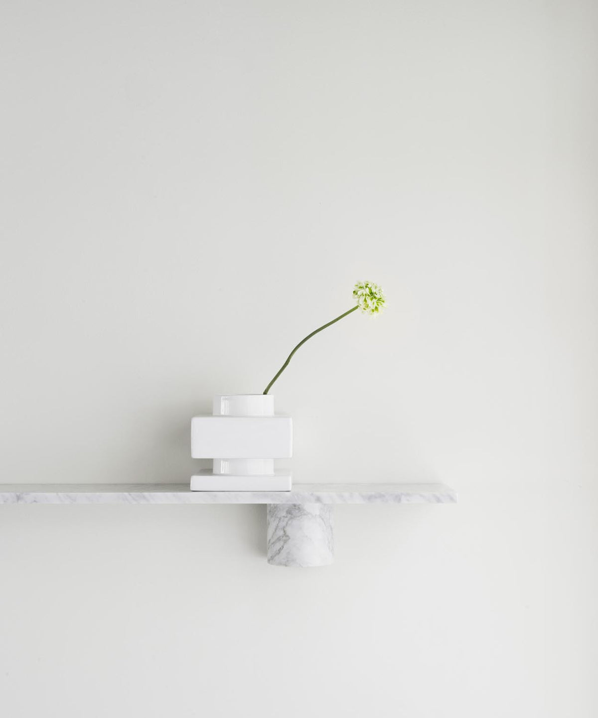 Weisses Wandregal aus massivem Carrara Marmor mit abgerundeten Steinträgern, montiert an einer Wand, skandinavisches Design von Normann Copenhagen.