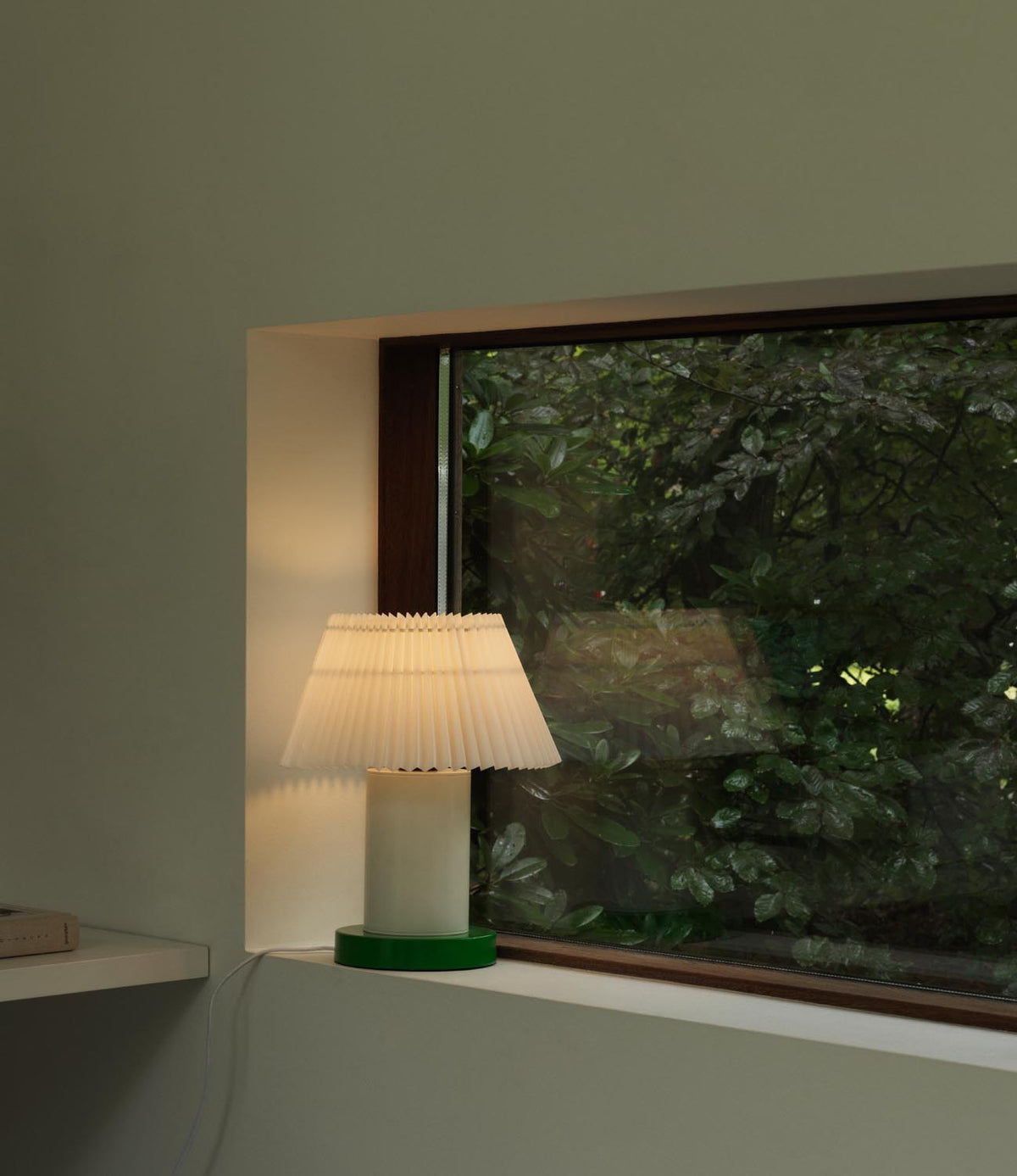 Tischleuchte Cellu EU von Normann Copenhagen in Hellgrün mit plissiertem PVC-Lampenschirm, Aluminiumstiel und Stahlsockel aus rostfreiem Stahl.