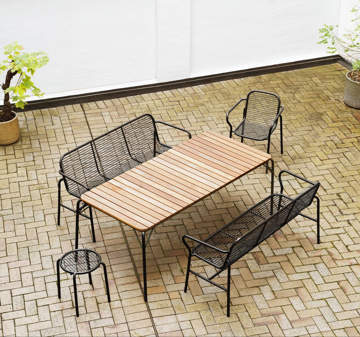 Foto einer schwarzen Vig Esszimmerbank von Normann Copenhagen aus doppelt pulverbeschichtetem Stahl mit schlichtem Gestell für den Aussenbereich.