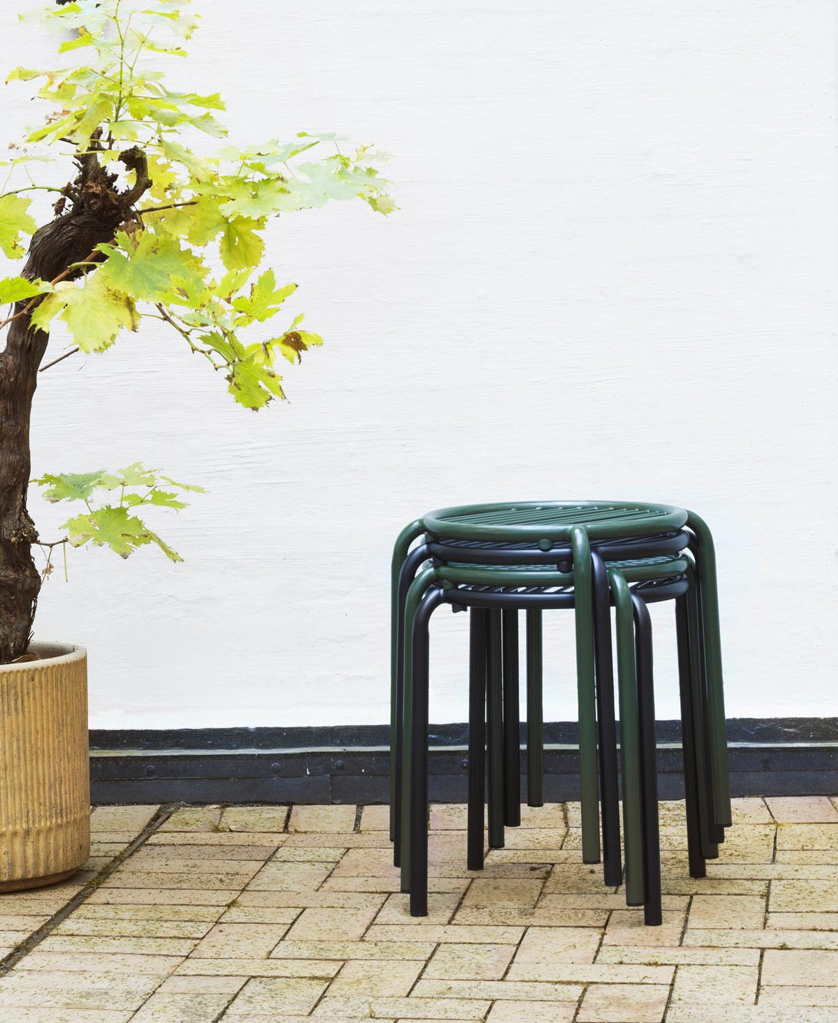 Schwarzer Vig Hocker aus doppelt pulverbeschichtetem Stahl mit runder Sitzfläche und schlanken Beinen, Outdoor-Möbel von Normann Copenhagen.