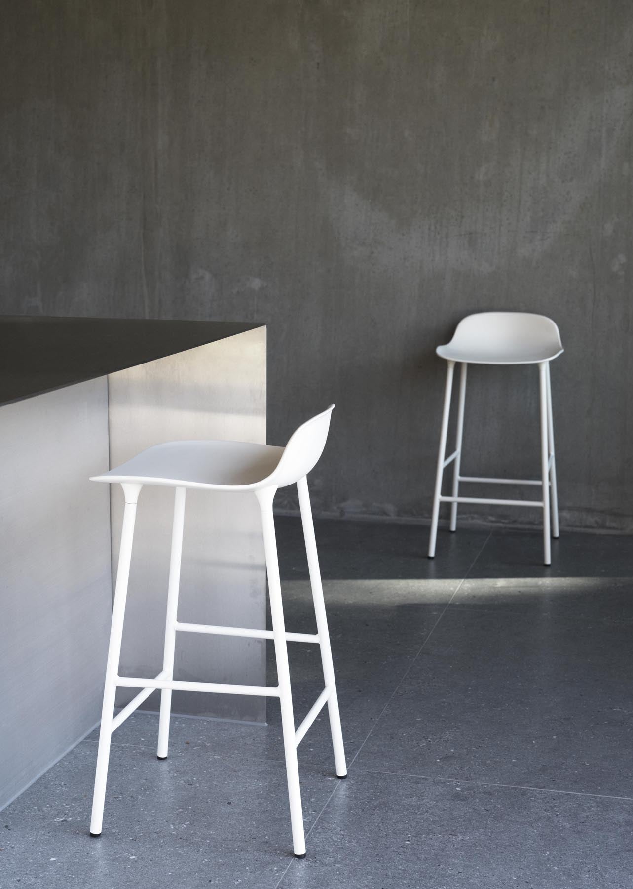 Erleben Sie den Form Barstuhl 65 cm in Warmem Grau und Stahl von Normann Copenhagen – ein harmonisches Design, das Stil und Funktionalität perfekt kombiniert.