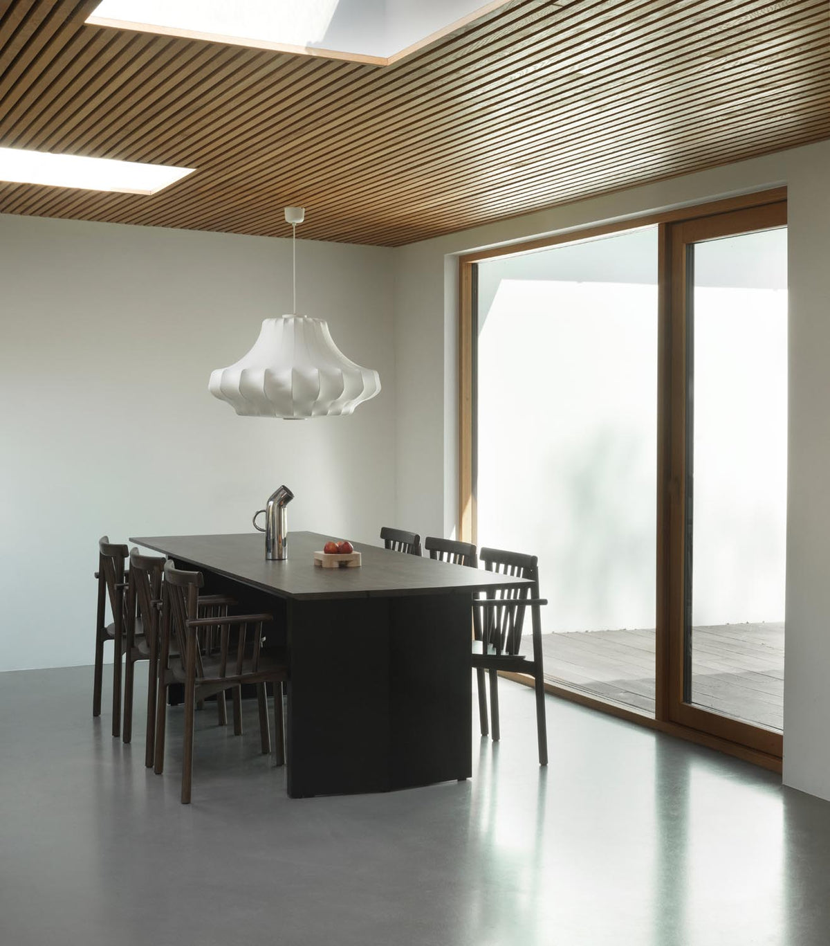 Esstisch Panel Table von Normann Copenhagen mit dunkelbrauner Kiefernholzplatte und schwarzen Stahlbeinen, leicht schräg geschnitten.