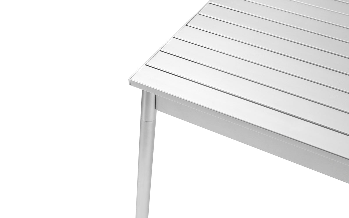 Esstisch Ex von Normann Copenhagen aus eloxiertem Aluminium, schlanke Tischplatte mit Profilstruktur, vier leicht angewinkelte Beine, Farbe Aluminium.
