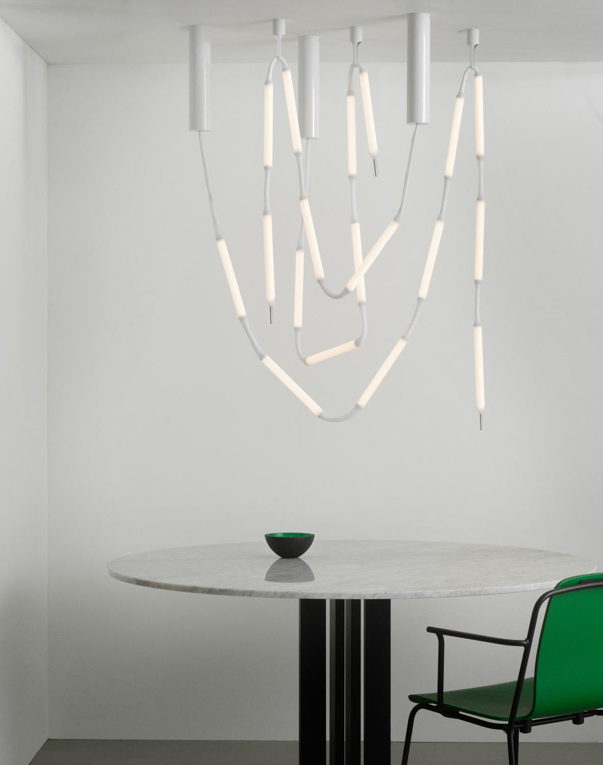 Weisse Pendelleuchte Reb Lampe 8 aus PET und PMMA mit netzartigem Acrylrohr, acht LED-Module an einem langen Kabel hängend.