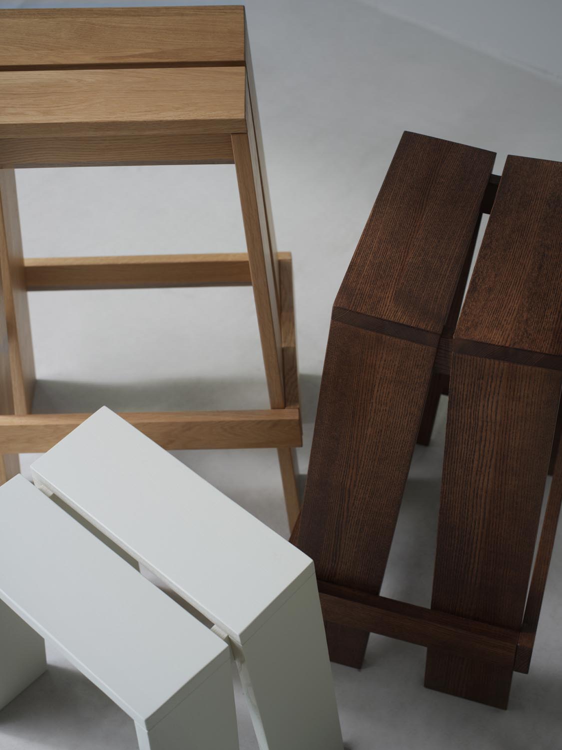 Hocker Let von Normann Copenhagen aus lackierter Eiche mit zwei parallelen, leicht geneigten Holzplanken als Sitzfläche und Beinen.