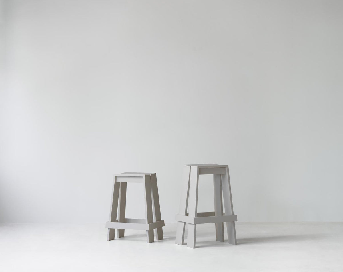 Barhocker Let 65 cm von Normann Copenhagen aus lackierter Eiche mit zwei parallelen, leicht geneigten Holzbrettern als Sitzfläche.