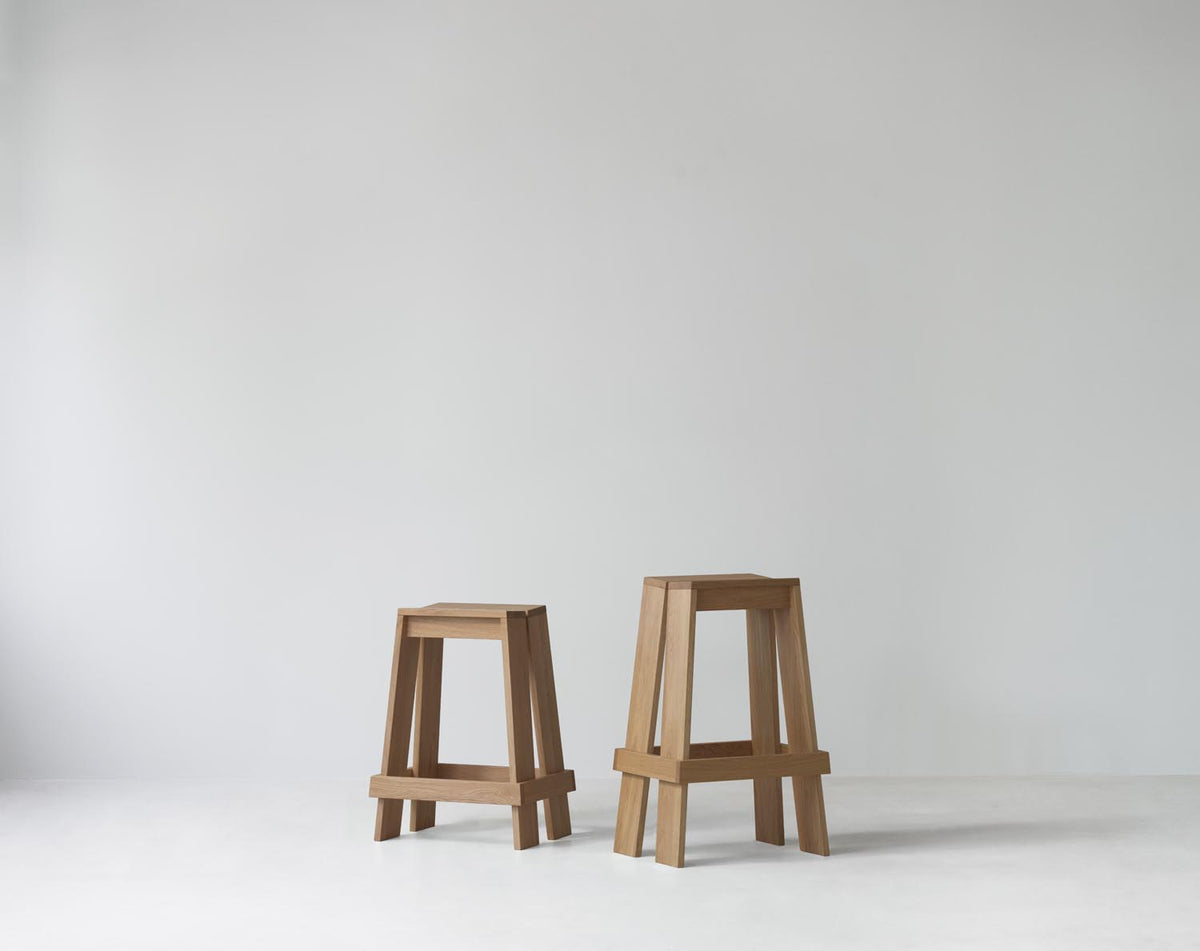 Barhocker Let 75 cm von Normann Copenhagen aus lackierter Eiche, mit zwei parallelen, leicht geneigten Holzplanken als Sitzfläche und Beinen.