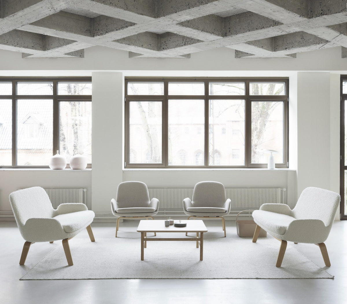 Era Lounge-Sessel von Normann Copenhagen in Grau mit Eichenbeinen, gepolsterter Sitzschale und geschwungener Rückenlehne.