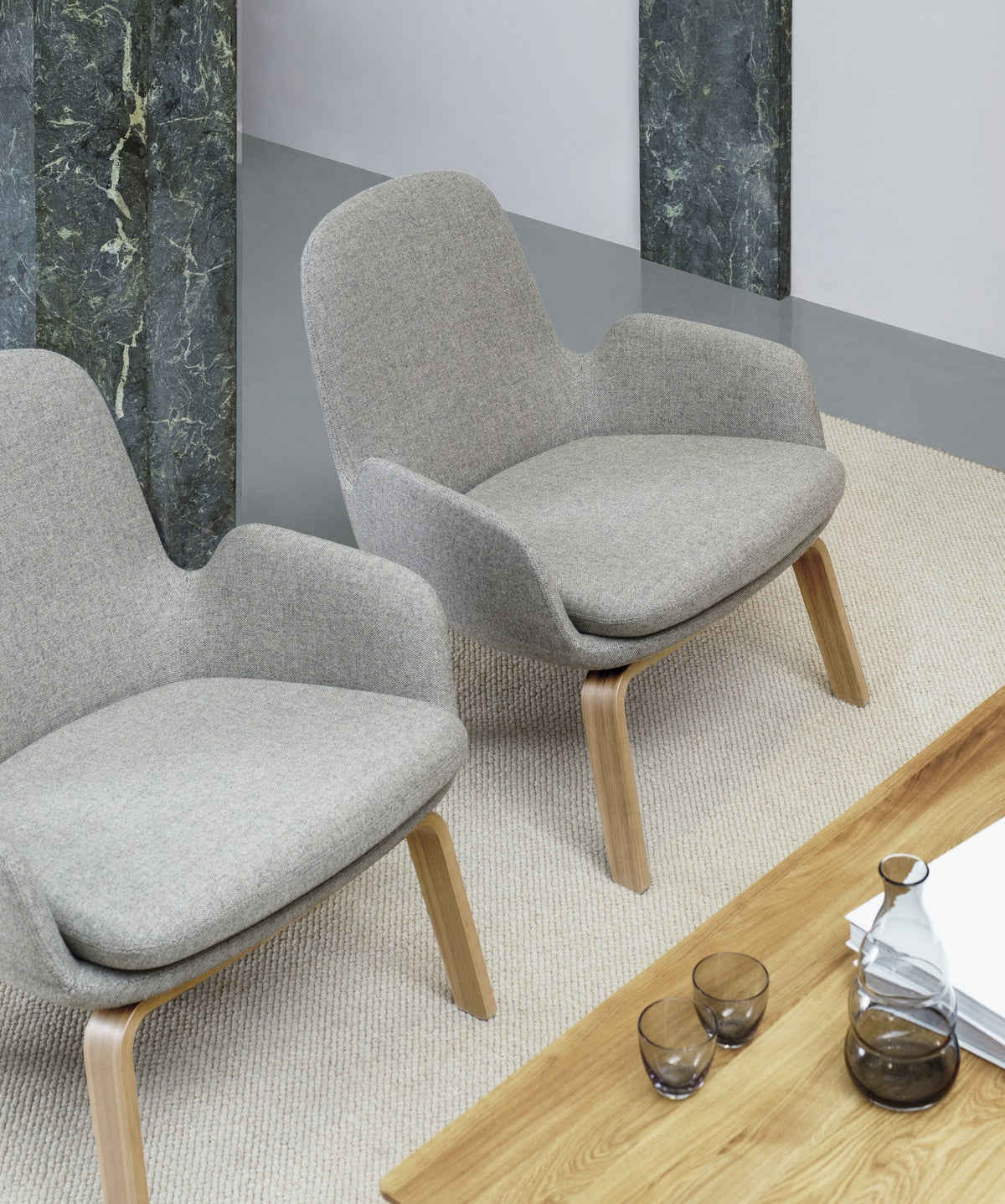 Era Lounge-Sessel von Normann Copenhagen in Grau mit gepolsterter Sitzschale und Beinen aus Walnussholz, geschwungene Form.