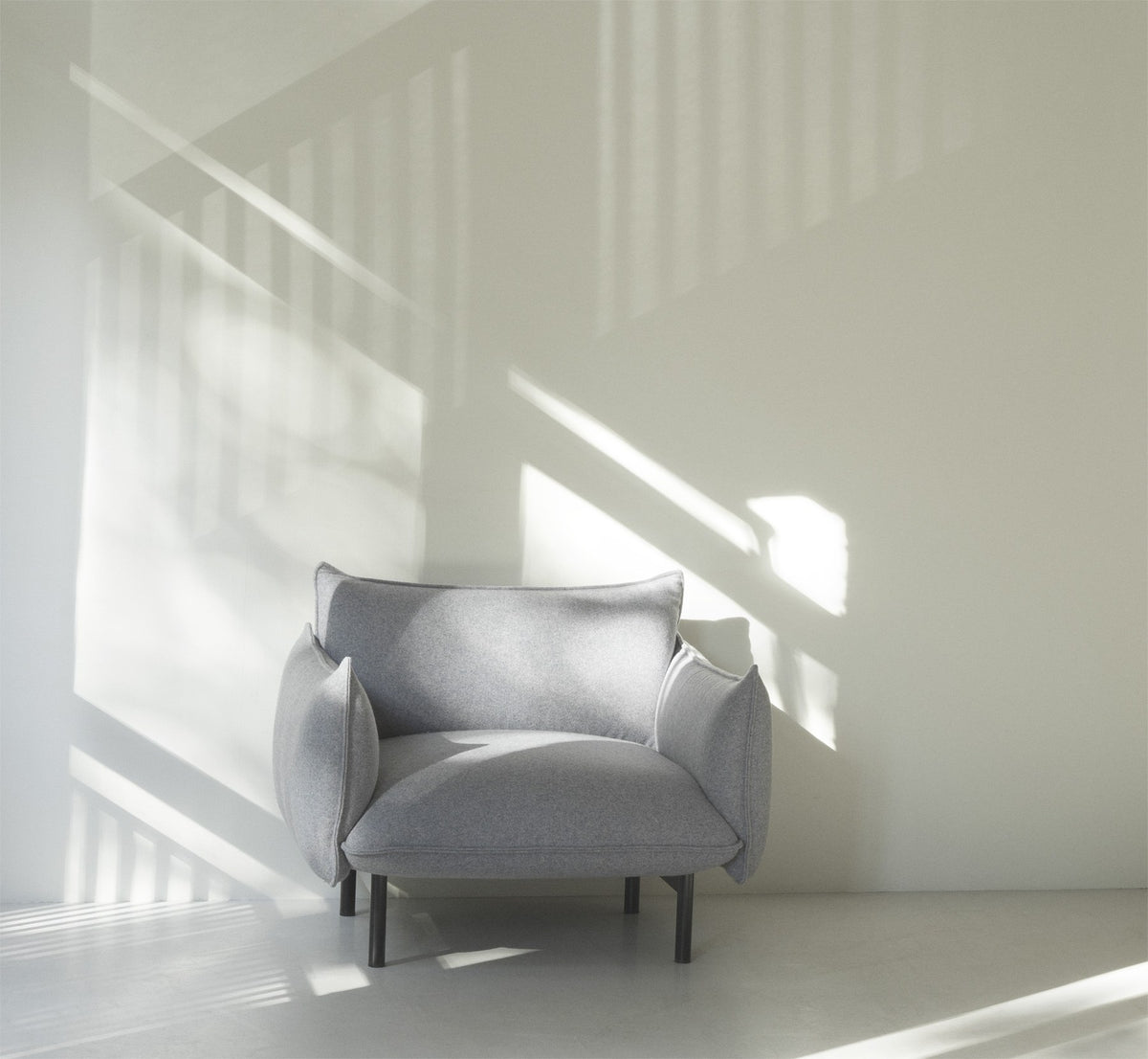 Ark Lounge-Sessel von Normann Copenhagen in Grau, gepolsterte Sitzfläche mit geschwungener Form und Beinen aus pulverbeschichtetem Stahl.