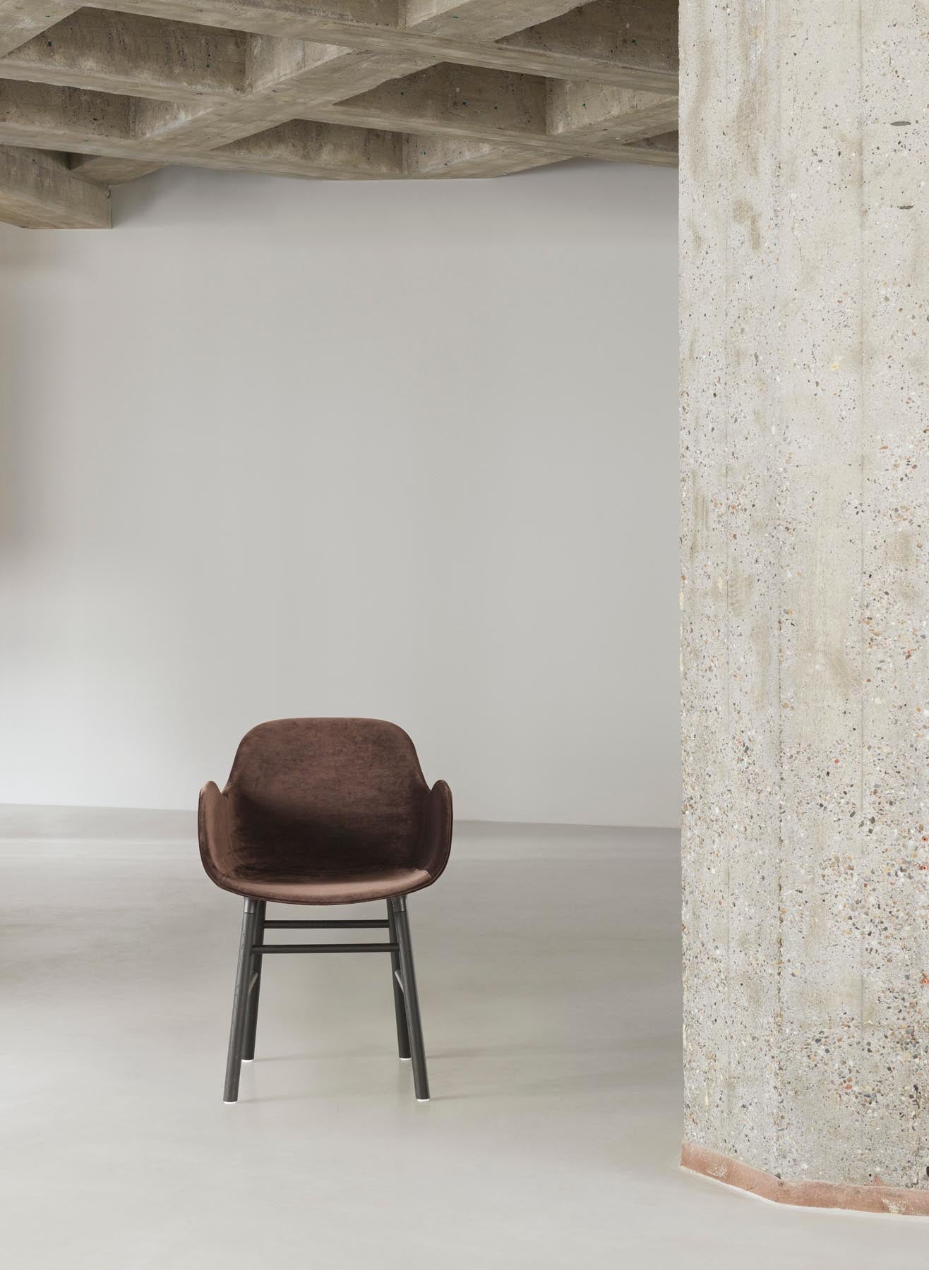 Der Form Lehnstuhl von Normann Copenhagen vereint elegantes Design mit gepolsterter Bequemlichkeit und stabiler Stahlkonstruktion in edlem Schwarz.