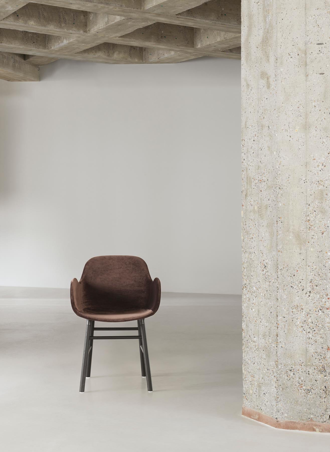 Stilvoller gepolsterter Lehnstuhl aus Walnuss und Ultra Leder von Normann Copenhagen. Perfekt für moderne Wohnkonzepte und gemütliche Akzente.