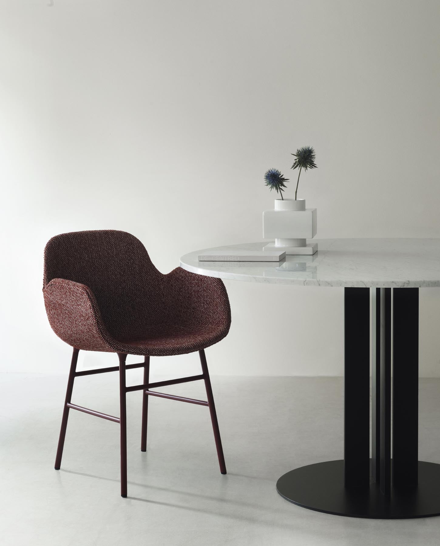 Der Form Lehnstuhl von Normann Copenhagen vereint elegantes Design mit gepolsterter Bequemlichkeit und stabiler Stahlkonstruktion in edlem Schwarz.