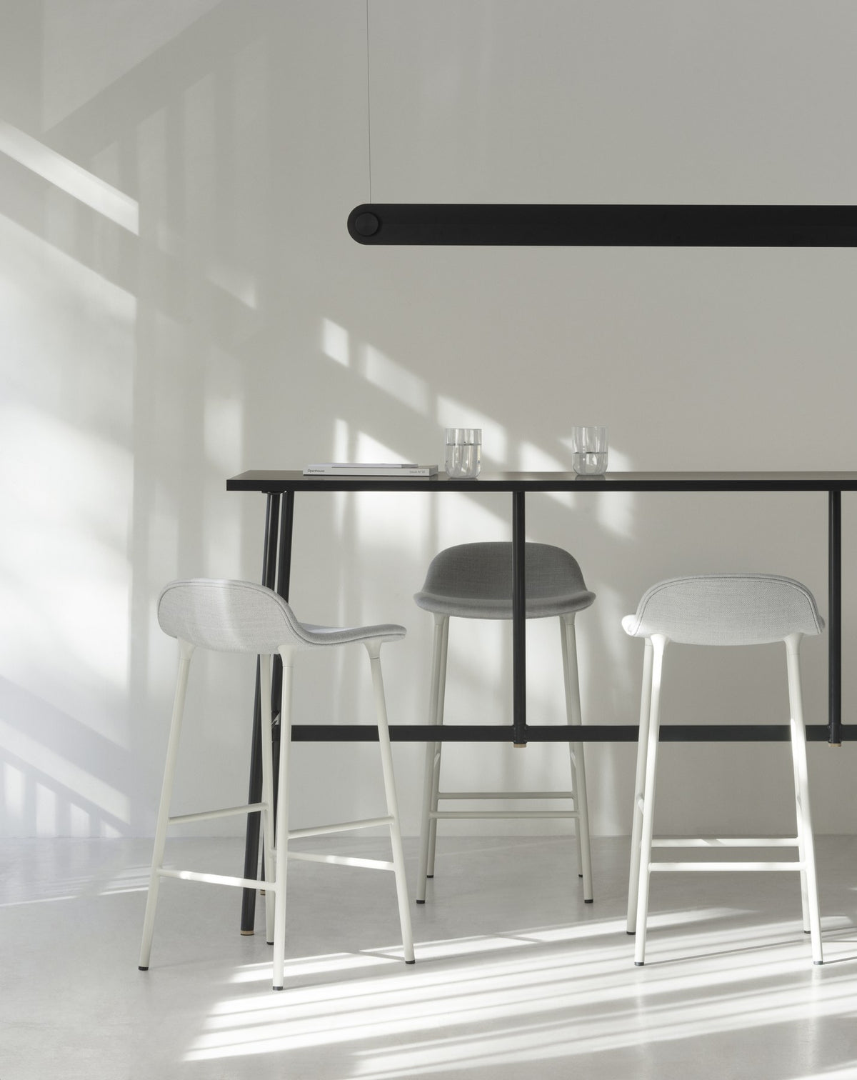 Form Barstuhl von Normann Copenhagen in Grau, gepolsterte Sitzschale, Chrom-Gestell mit vier Beinen, Sitzhöhe 65 cm.