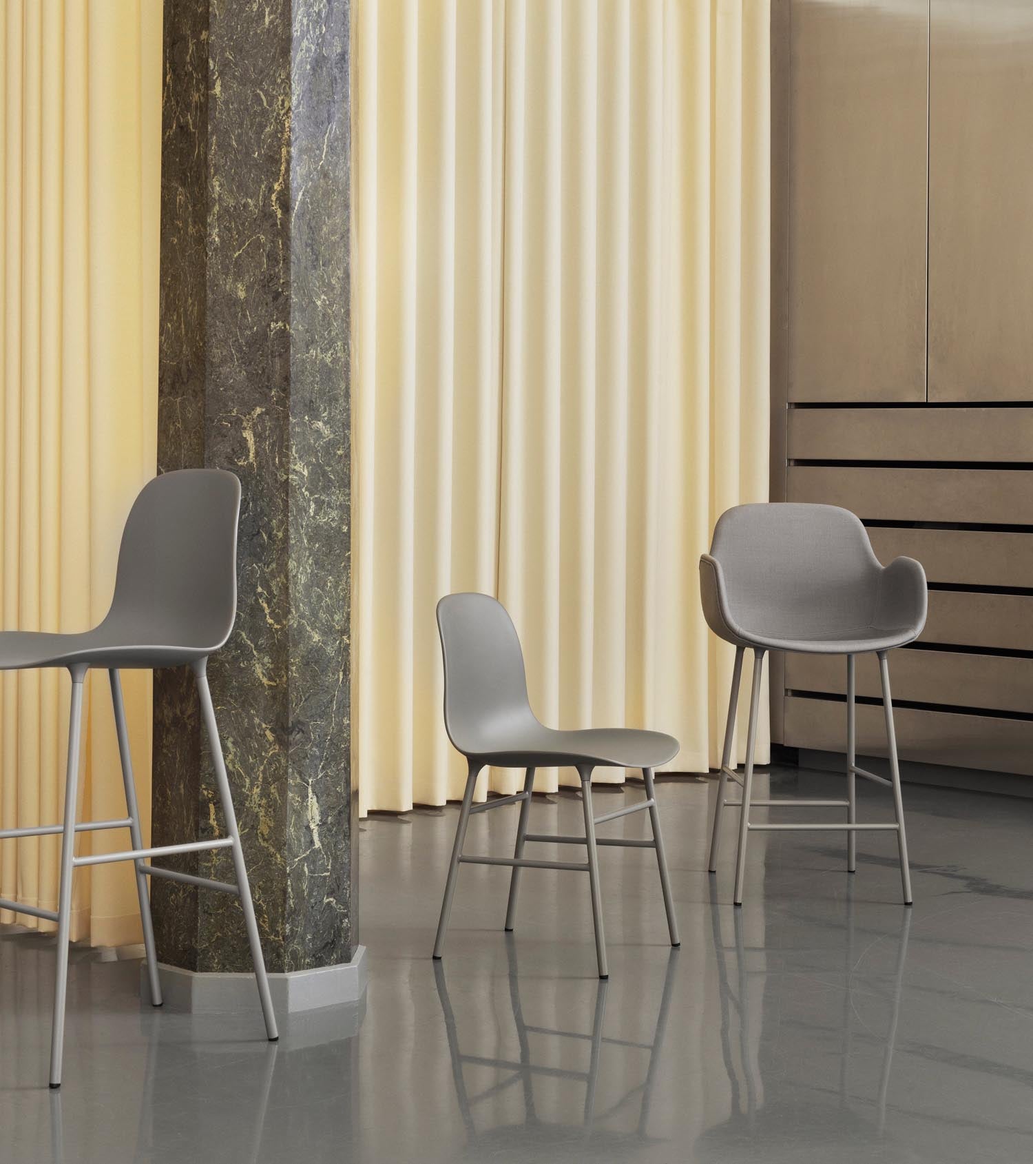 Entdecken Sie den eleganten Form Barstuhl mit Armlehne von Normann Copenhagen. Gepolstert in Grau, vereint er Komfort und zeitgemäßes Design.