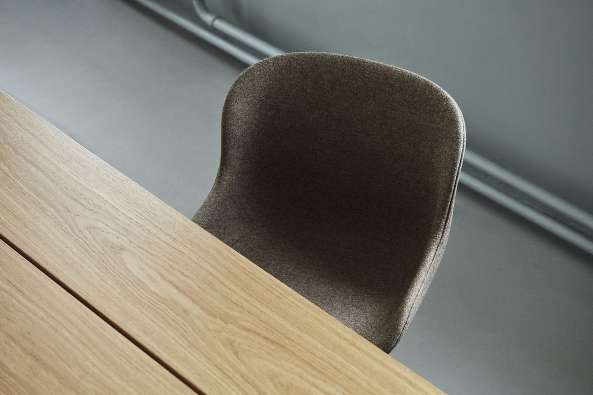 Drehstuhl Hyg von Normann Copenhagen mit gepolsterter Sitzschale in Braun, organisch geschwungener Form und vierstrahligem Aluminiumfuss.