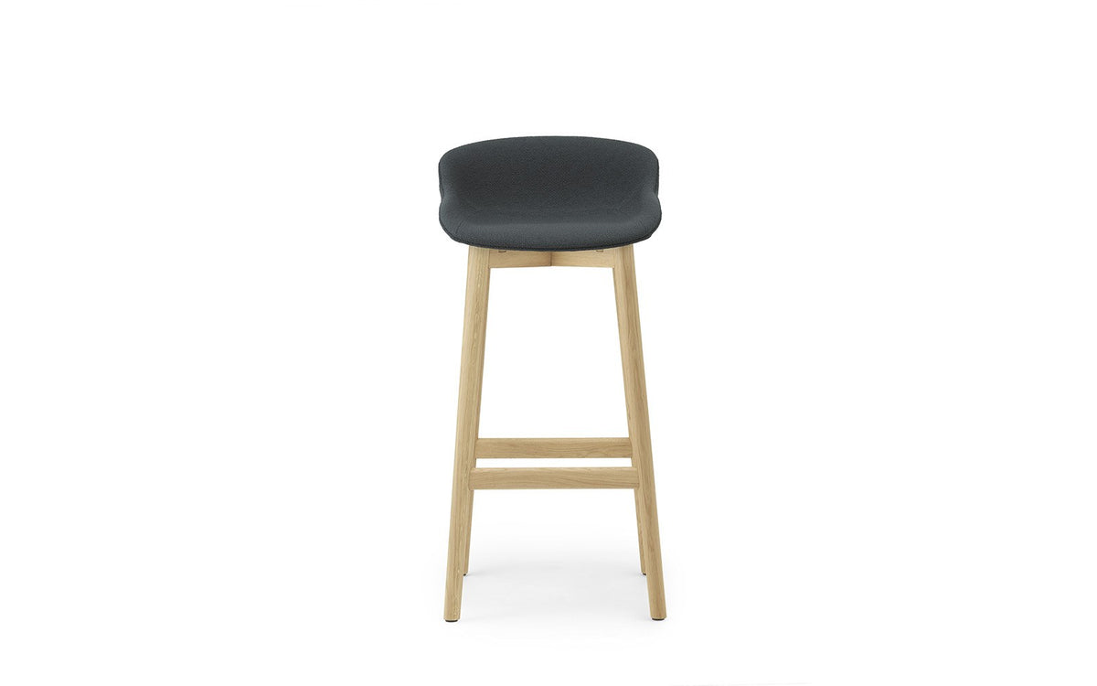 Hyg Barhocker von Normann Copenhagen mit vollgepolsterter Sitzschale aus Polypropylen, Gestell aus lackierter Eiche, Sitzhöhe 75 cm.
