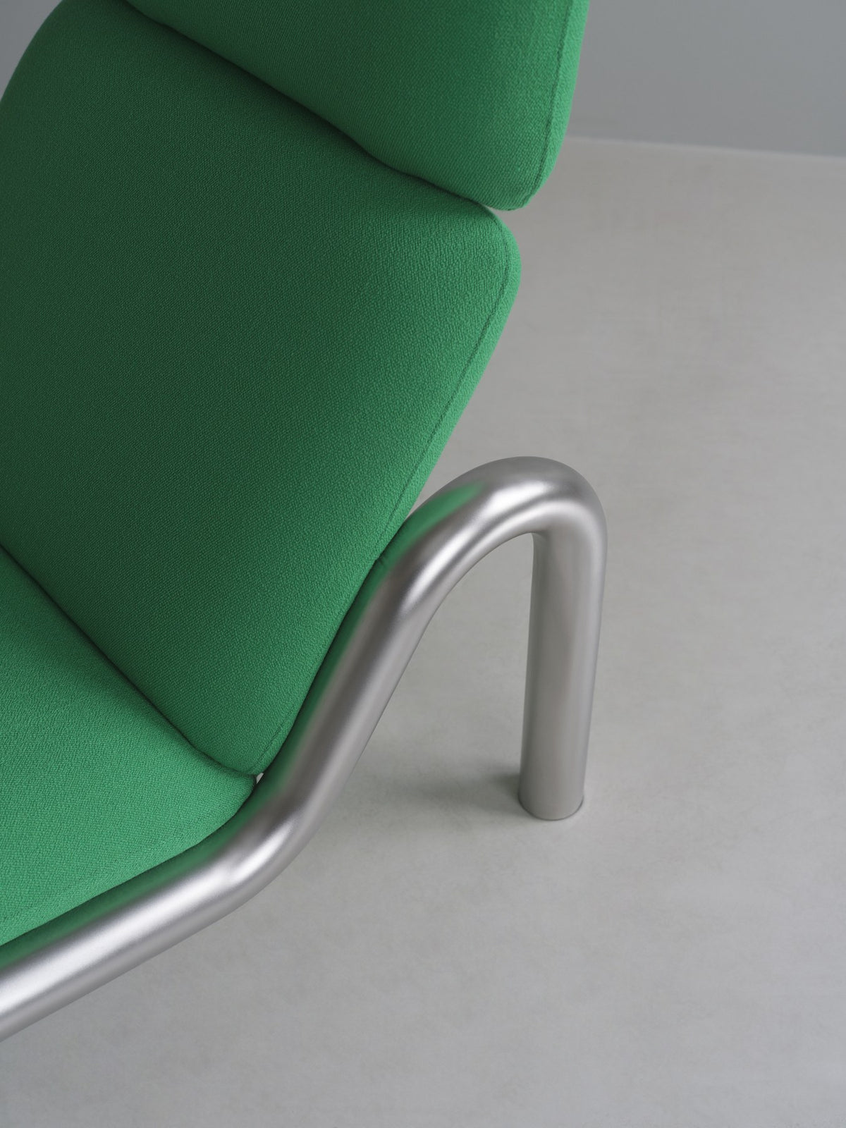 Tube Lounge-Sessel von Normann Copenhagen in Weiss, mit gebogenem Edelstahl-Rohrgestell und gepolstertem Sitz sowie hoher Rückenlehne.
