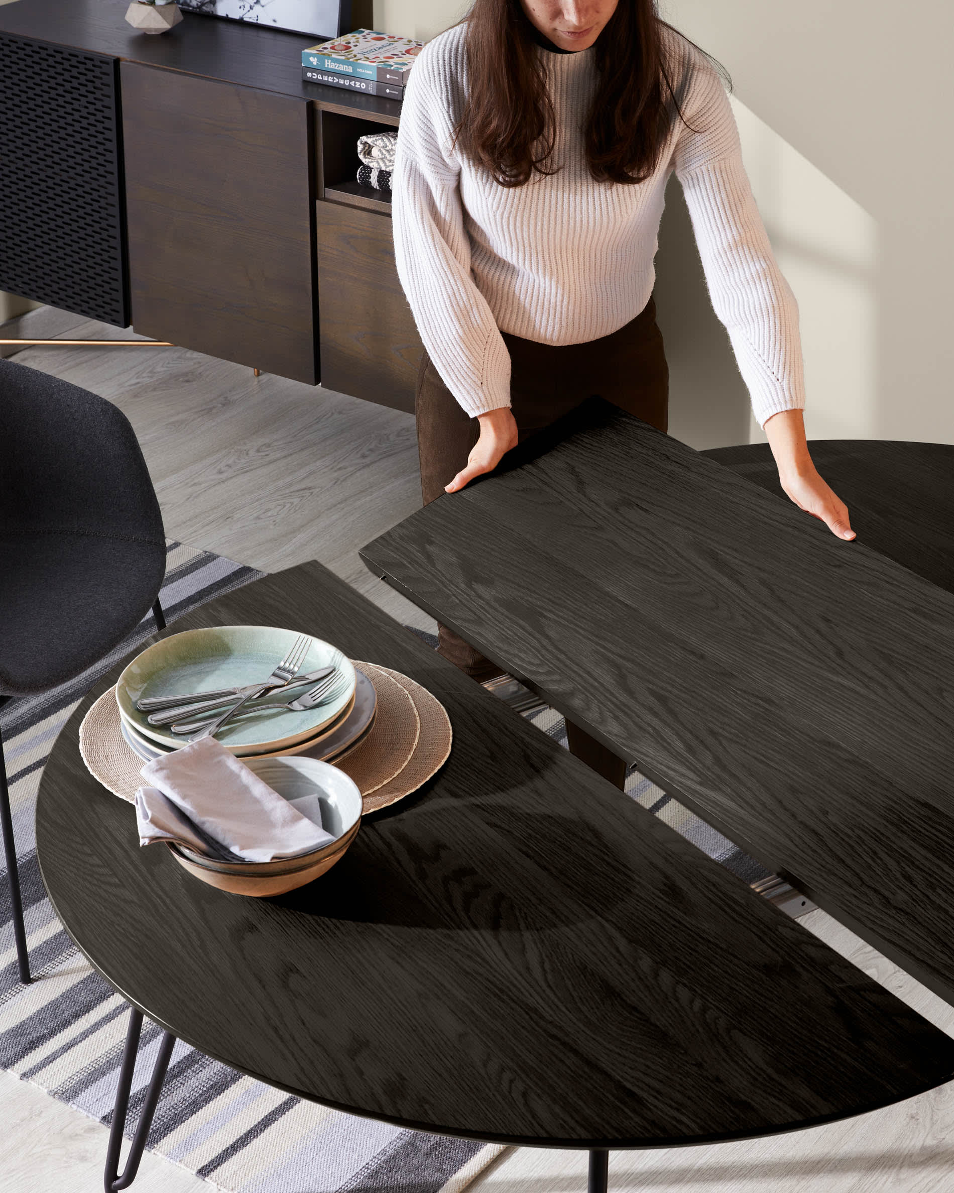 Eleganter runder Esstisch mit ausziehbarer Funktion, Eschenfurnier und schwarzen Stahlbeinen, perfekt für moderne Esszimmer.