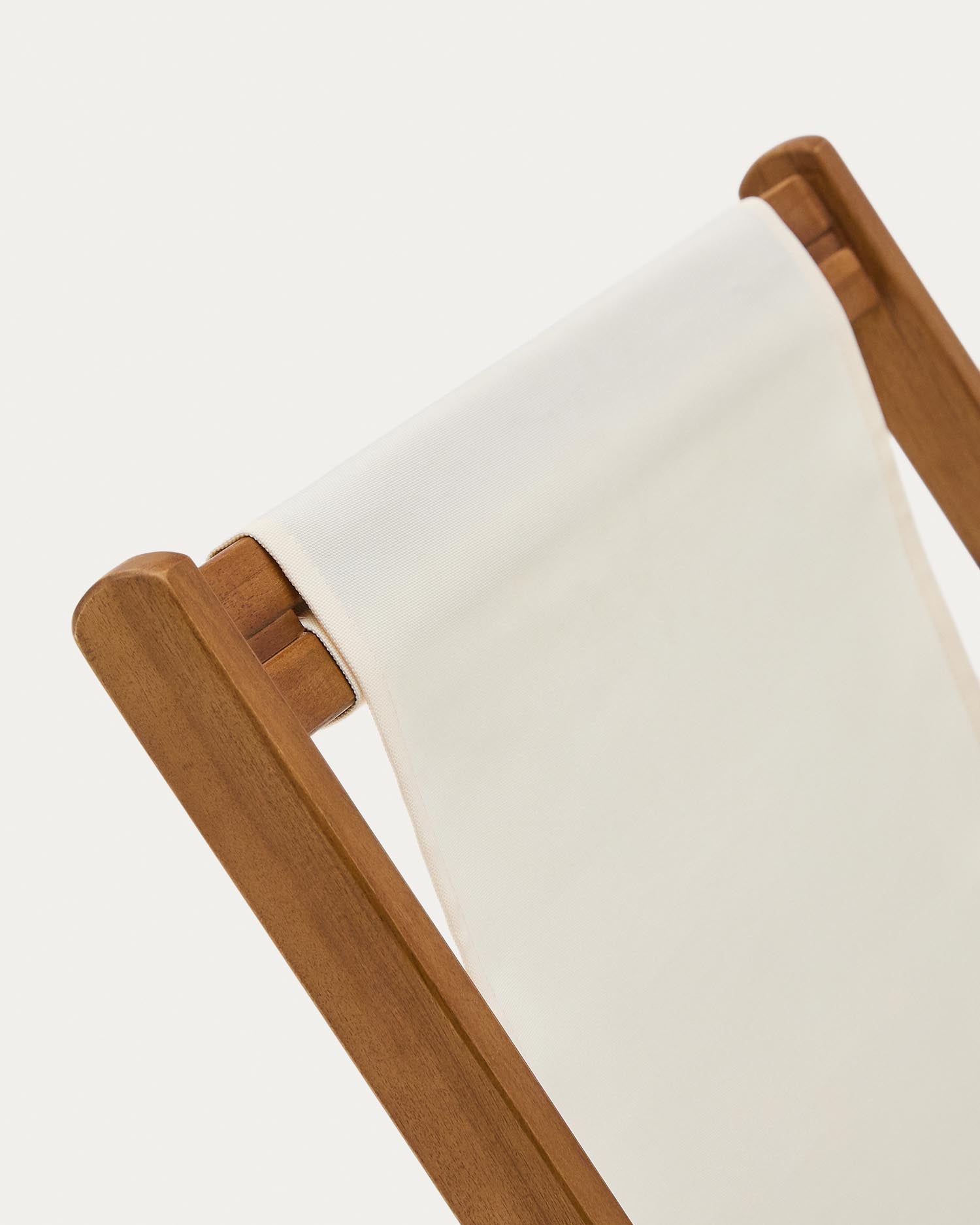 Der klappbare Outdoor-Liegestuhl Adredna für Kinder in Beige aus massivem Akazienholz vereint Nachhaltigkeit und modernes Design für entspannte Stunden im Freien.