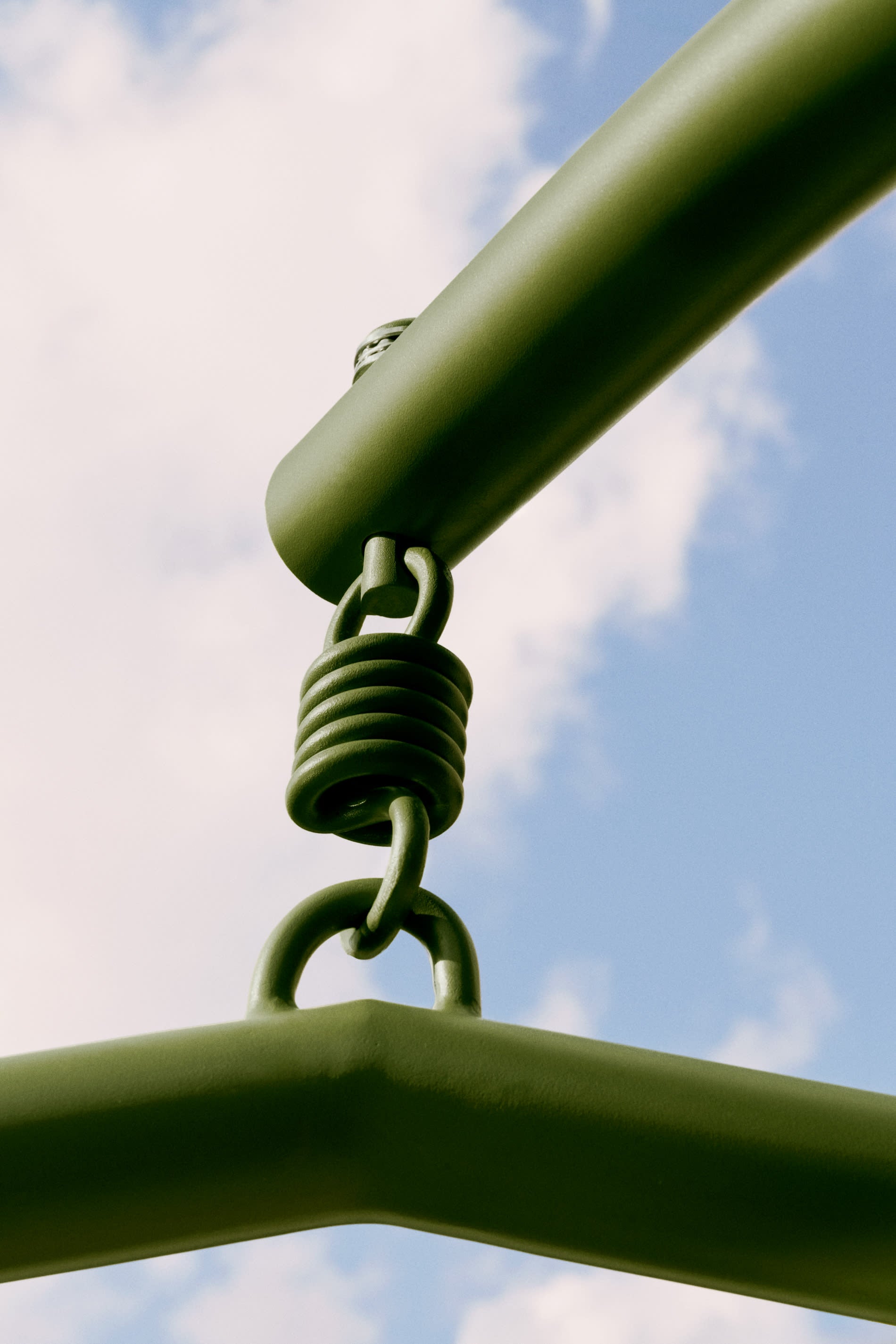 Moderner Hängesessel aus Aluminium und grünem Kunstrattan, ideal für entspannte Momente im Garten oder auf der Terrasse.