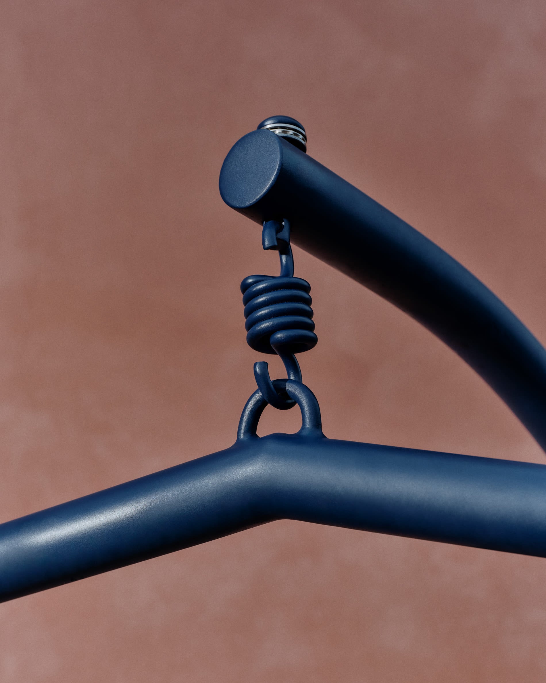 Eleganter Hängesessel aus Aluminium und blauem Rattan, perfekt für komfortable Momente in Haus oder Garten.