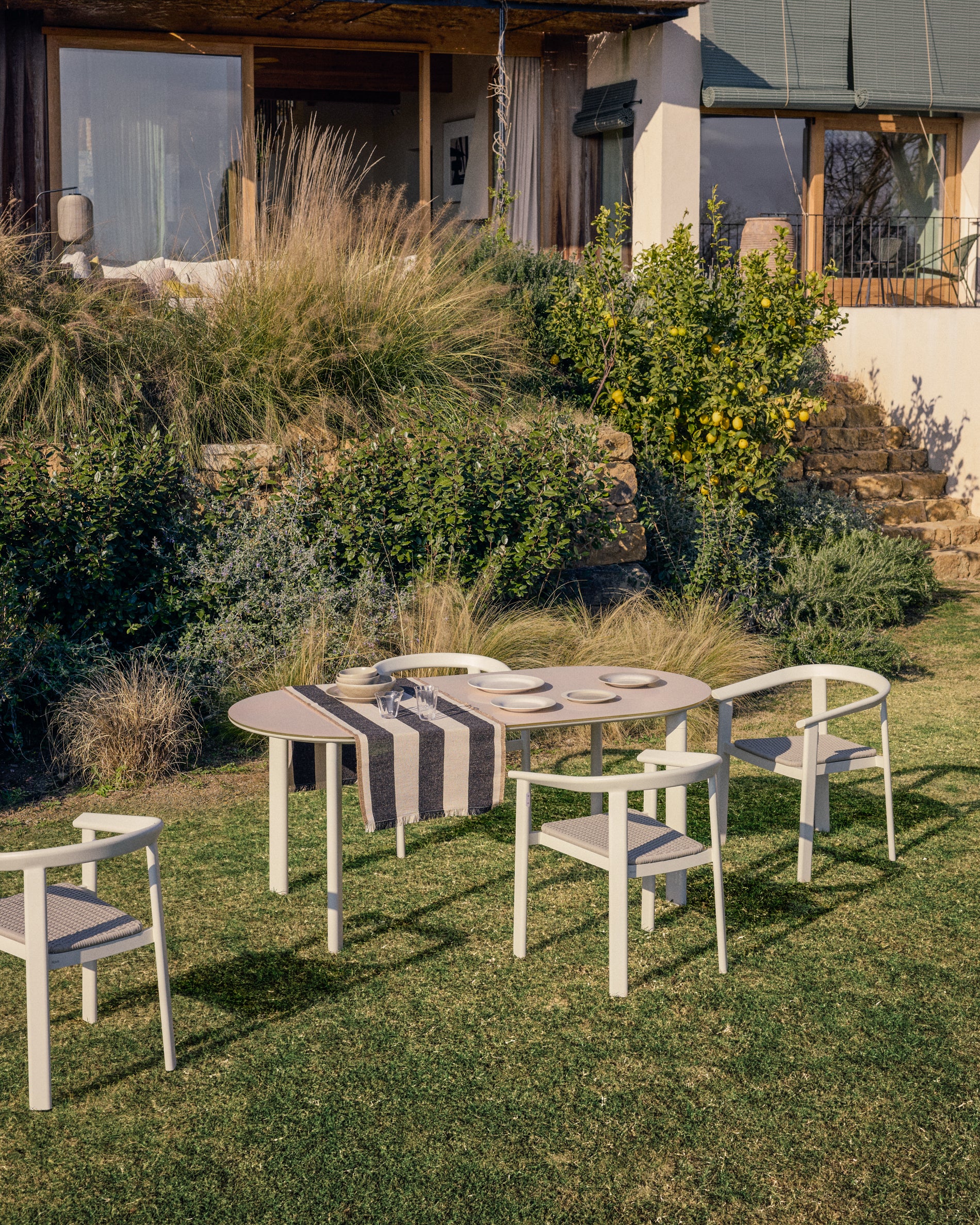 Moderner stapelbarer Stuhl Erice aus leichtem Aluminium und edlem ecrufarbenem Seil, perfekt für Garten und Terrasse.