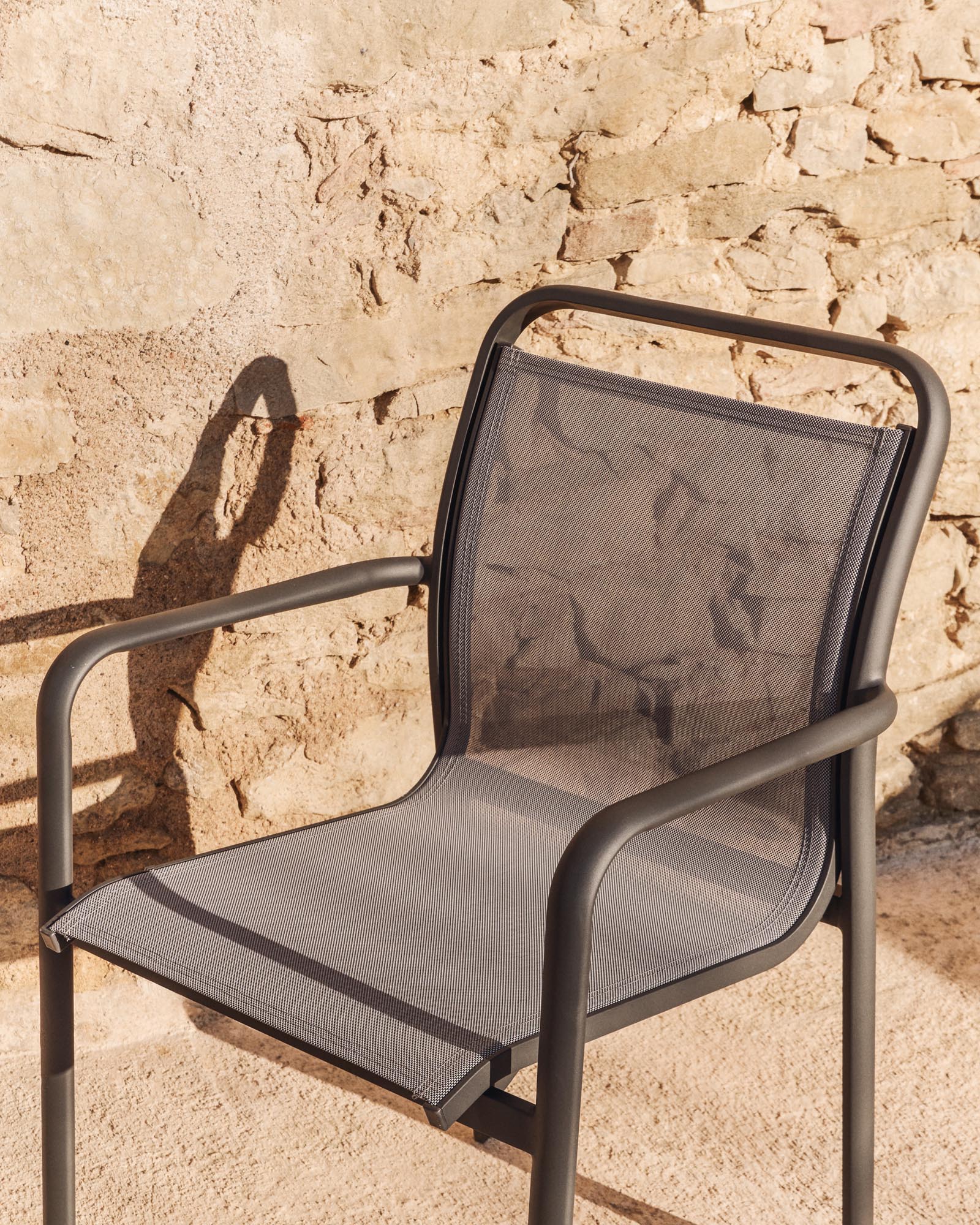 Eleganter stapelbarer Gartenstuhl Luri aus robustem Aluminium in Graphit, kombiniert mit stilvollem grauem Texteline für optimalen Komfort.